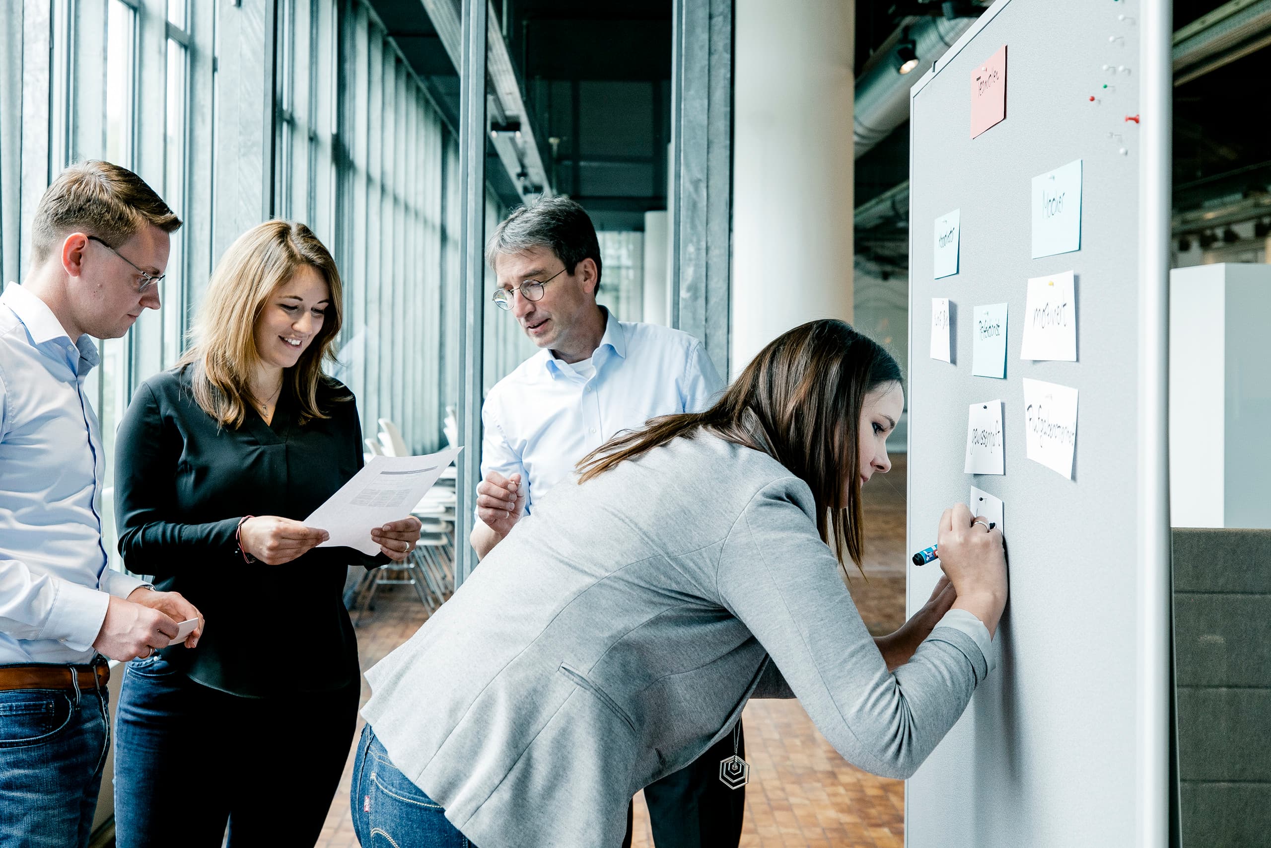 ERCO-Team arbeitet gemeinsam an einer Projektplanung mit Notizen an einer Tafel.