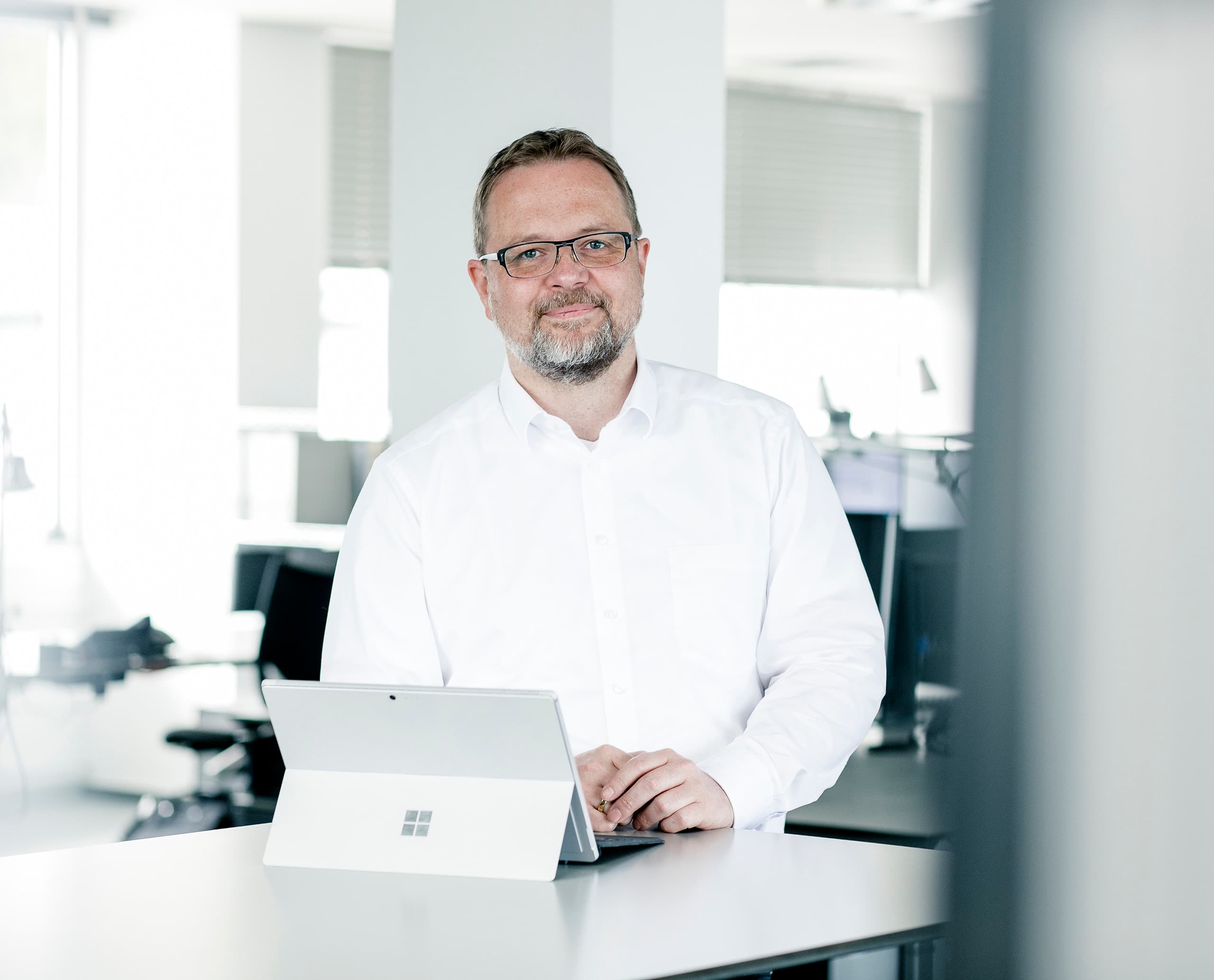 ERCO Mitarbeiter mit Tablet im Büro. Engagiert im Bereich Lichtplanung und innovative Lichtlösungen.