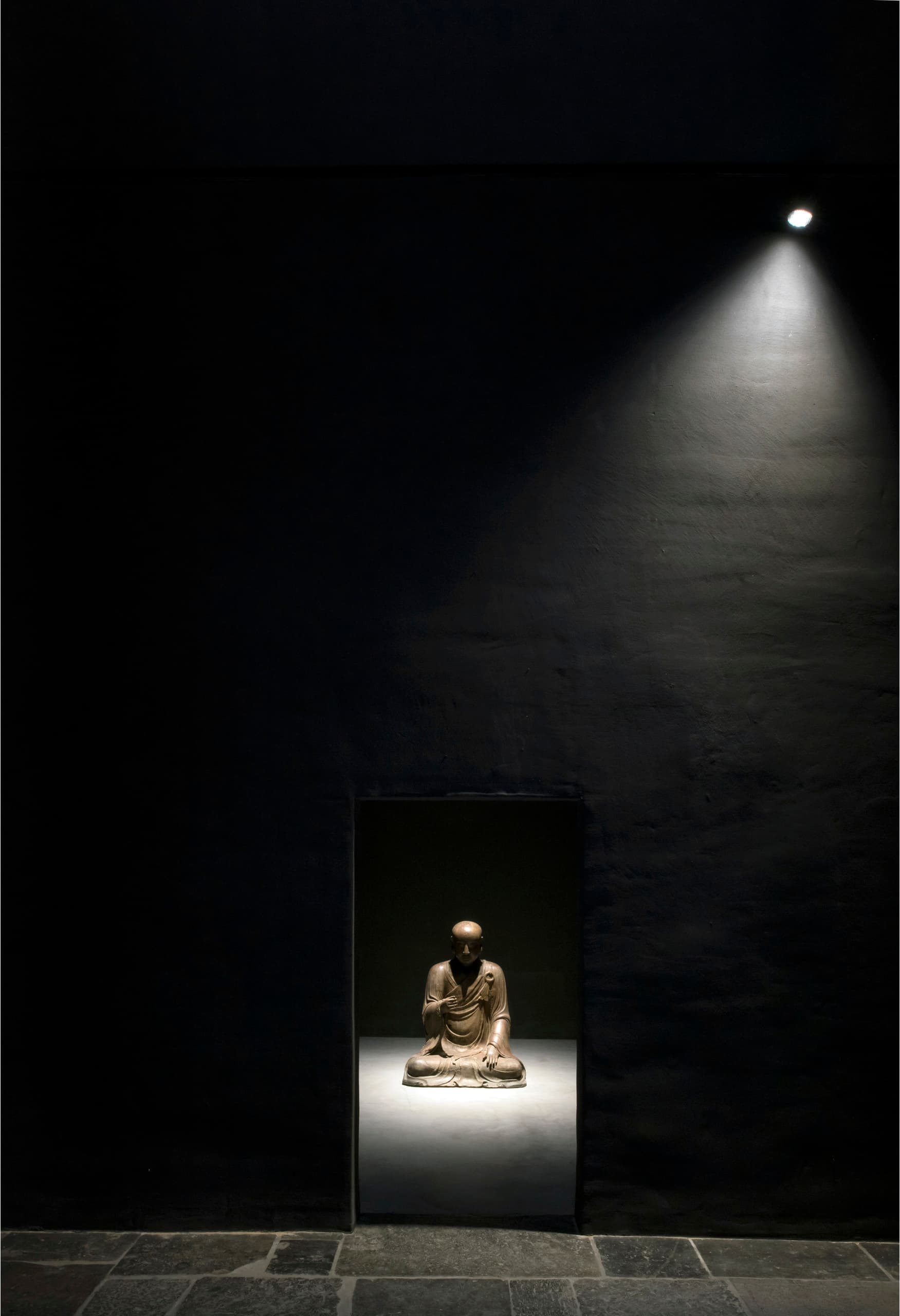 Beleuchtete Buddha-Statue in der Axel Vervoordt Gallery, betont durch ERCO LED-Spots.