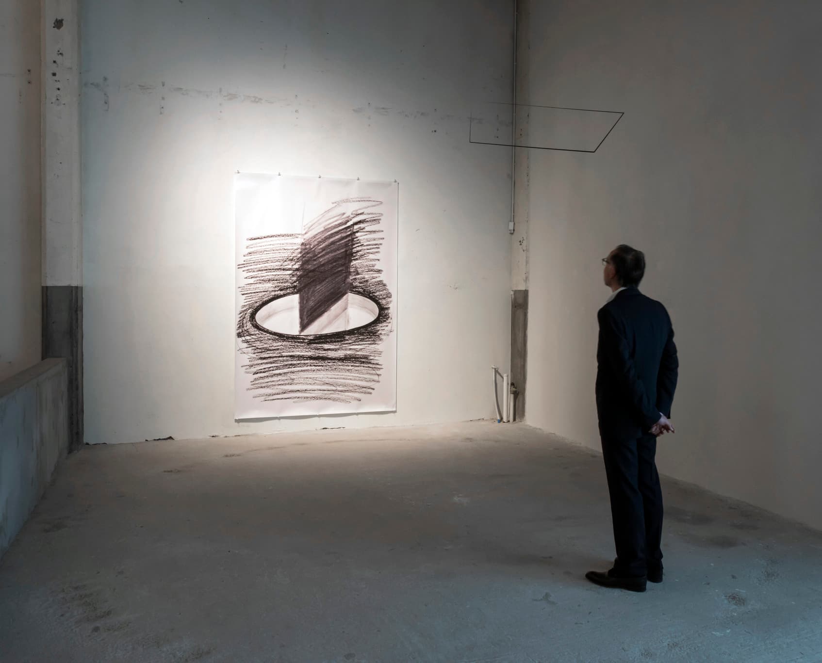 Mann betrachtet eine Zeichnung in der Axel Vervoordt Galerie, beleuchtet mit ERCO LED Strahlern.
