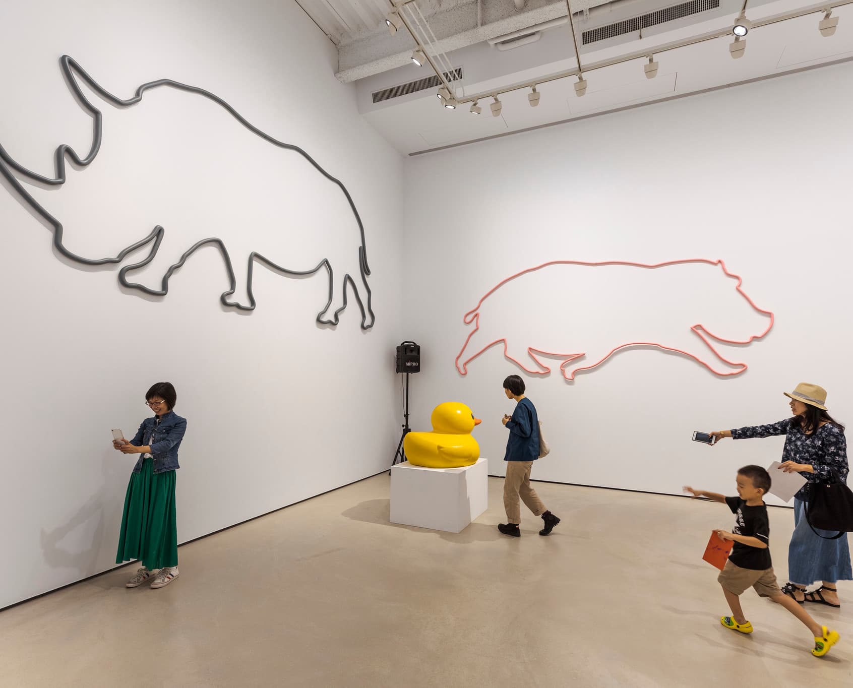 Wandwaschanlage im Museum: Tierische Kunstwerke und Besucher unter ERCO-Beleuchtung.