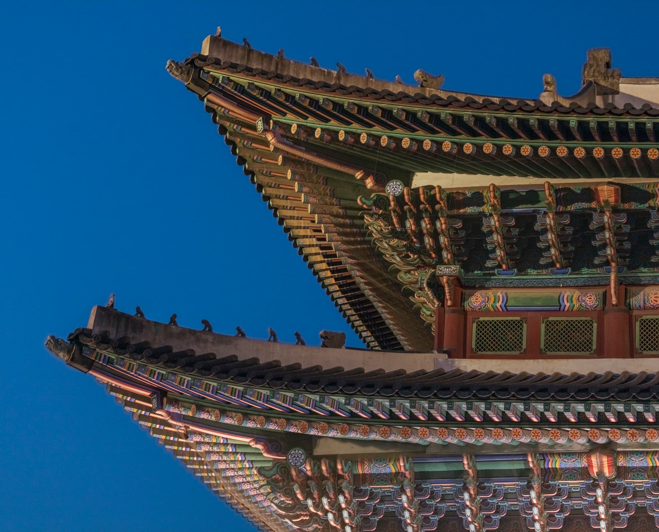Detailaufnahme der kunstvollen Pagodendacharchitektur des Gyeongbokgung Palastes, beleuchtet von ERCO.