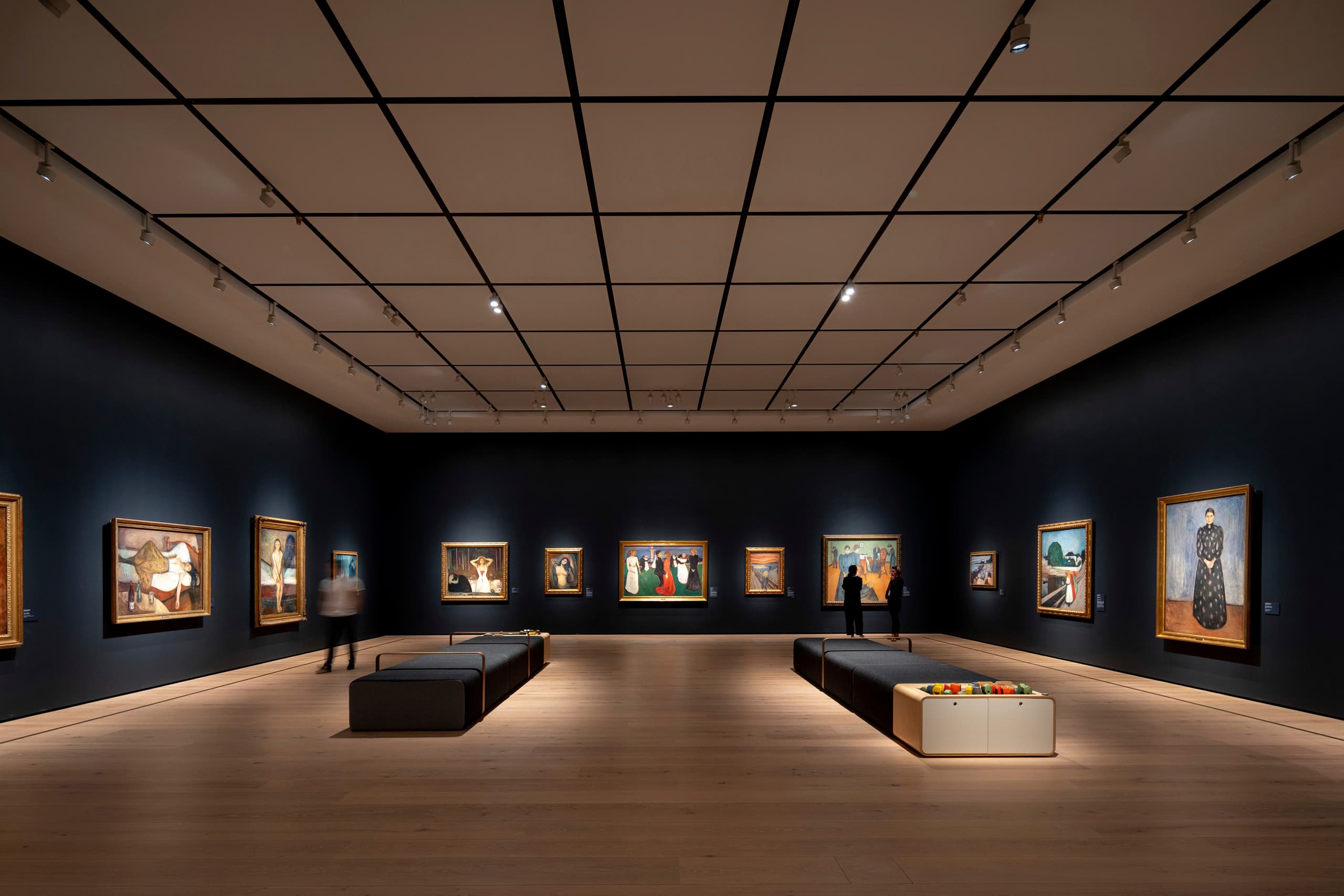 Akzentbeleuchtung in einer Kunstgalerie mit Gemälden, die mit Strahlern hervorgehoben werden.
