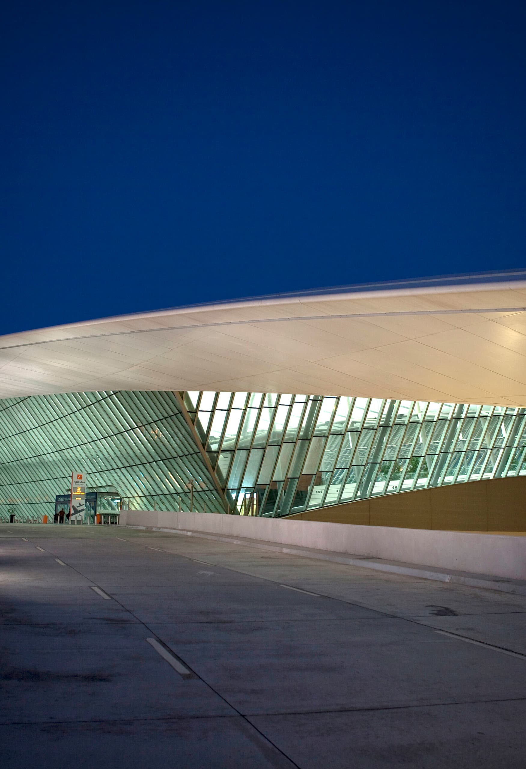 Carrasco International Airport bei Nacht, Montevideo, Uruguay. Beleuchtete, geschwungene Dachkonstruktion.