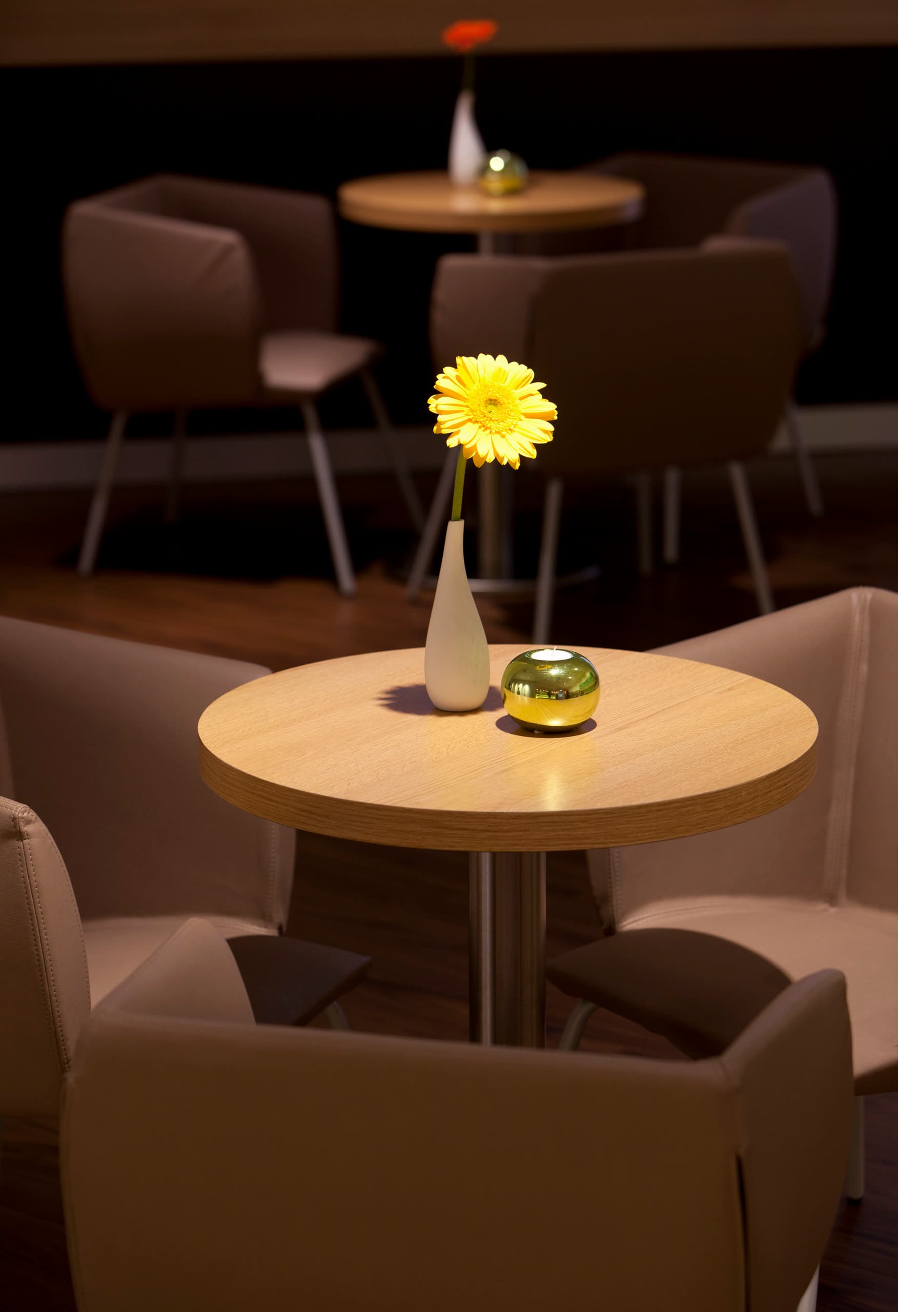 Gelbe Blume als Tischdeko im Ibis Hotel Bonn, beleuchtet mit ERCO LED-Leuchten.