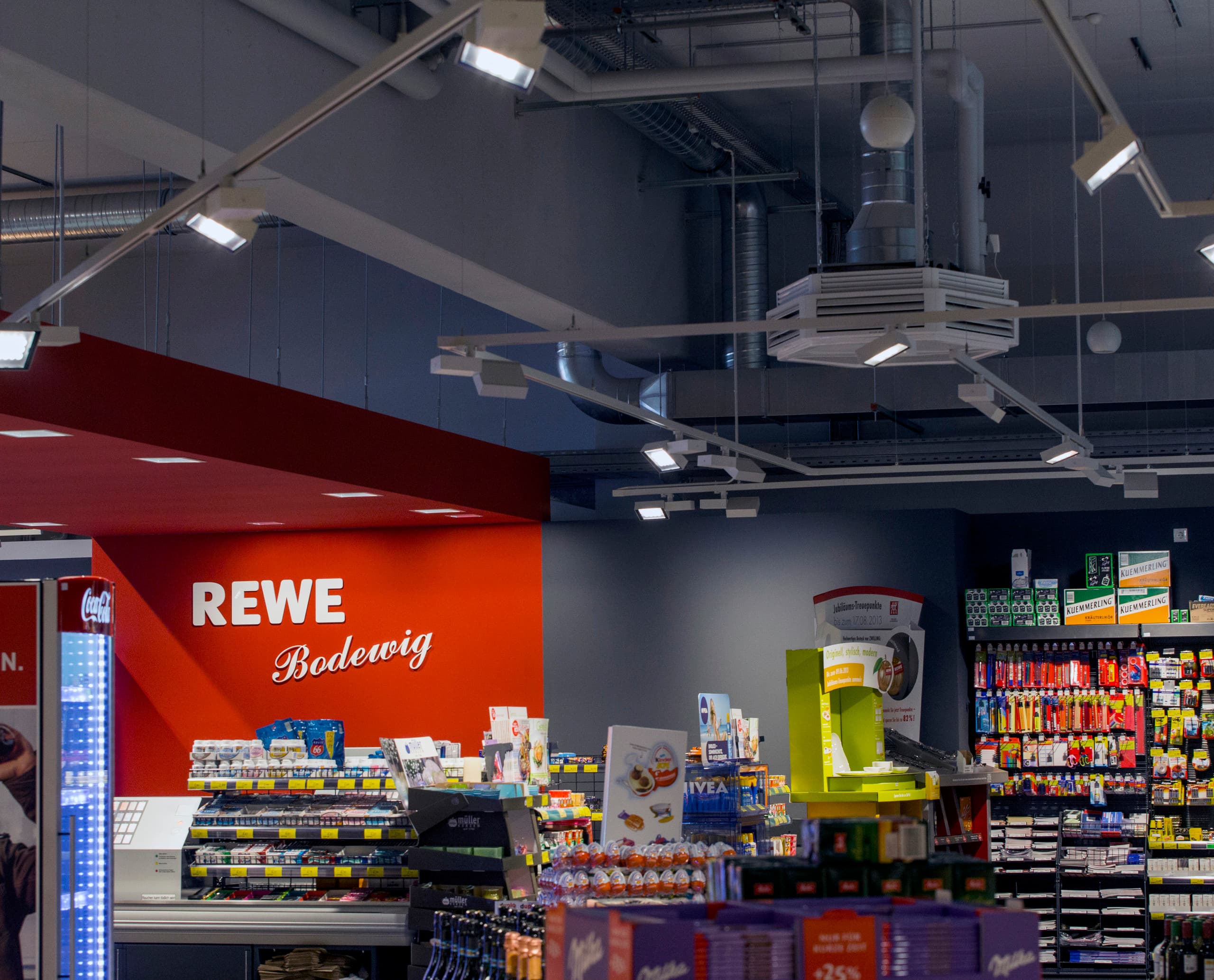 Opton LED-Leuchten im REWE-Supermarkt für energieeffiziente Akzentbeleuchtung.