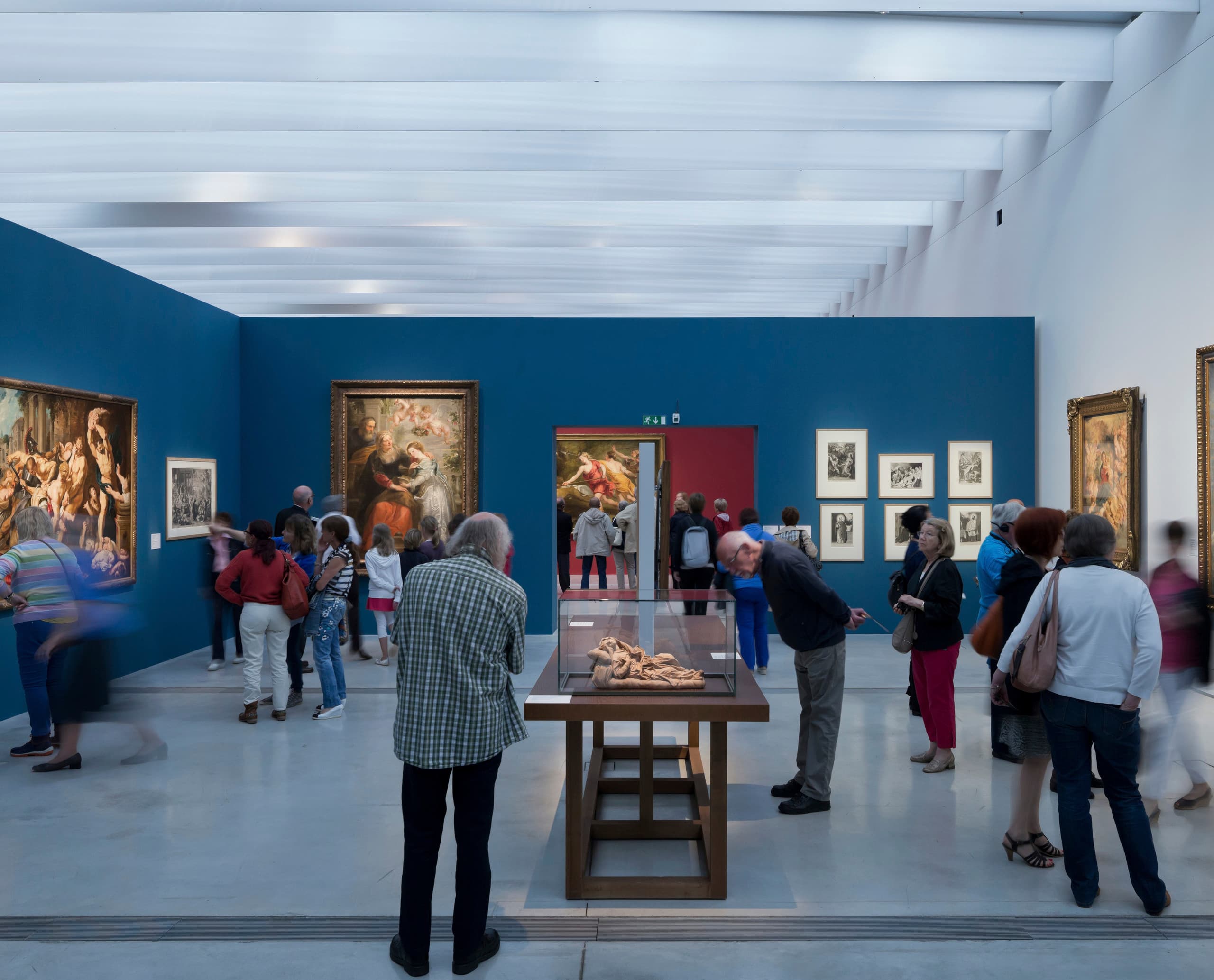 Besucher betrachten Kunstwerke im Louvre-Lens Museum, beleuchtet mit ERCO LED-Leuchten.