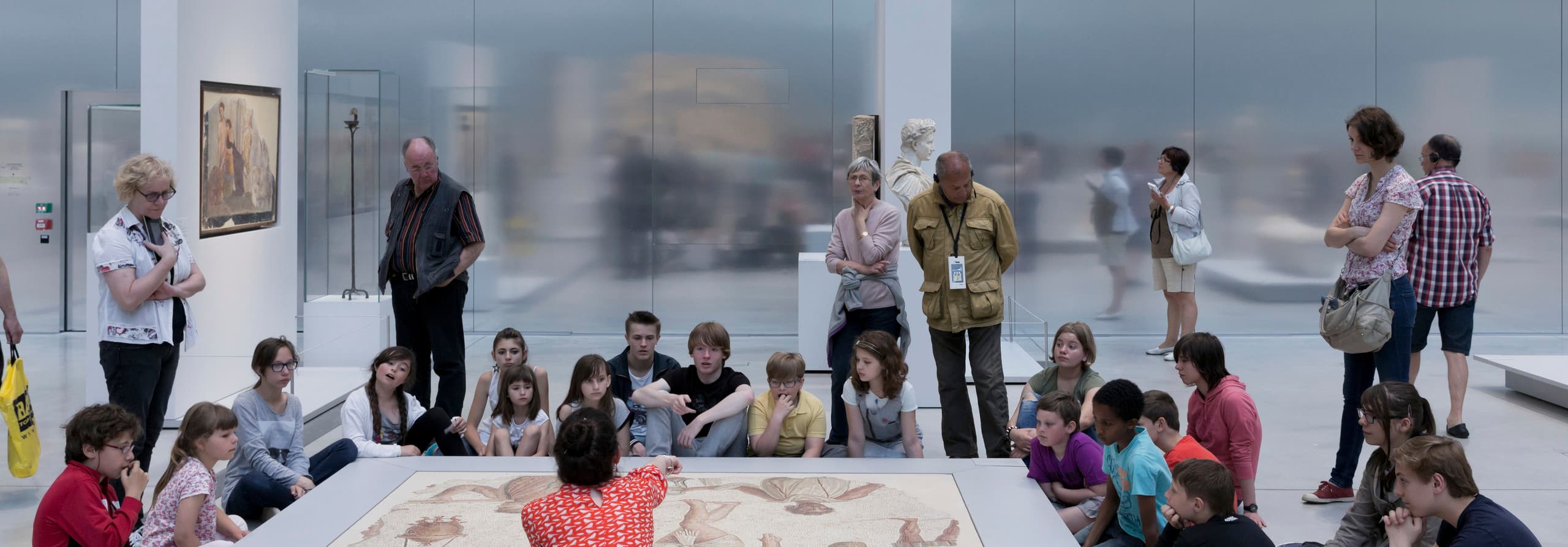 Schulklasse betrachtet ein Mosaik im Louvre Lens Museum, beleuchtet mit ERCO LED-Leuchten.