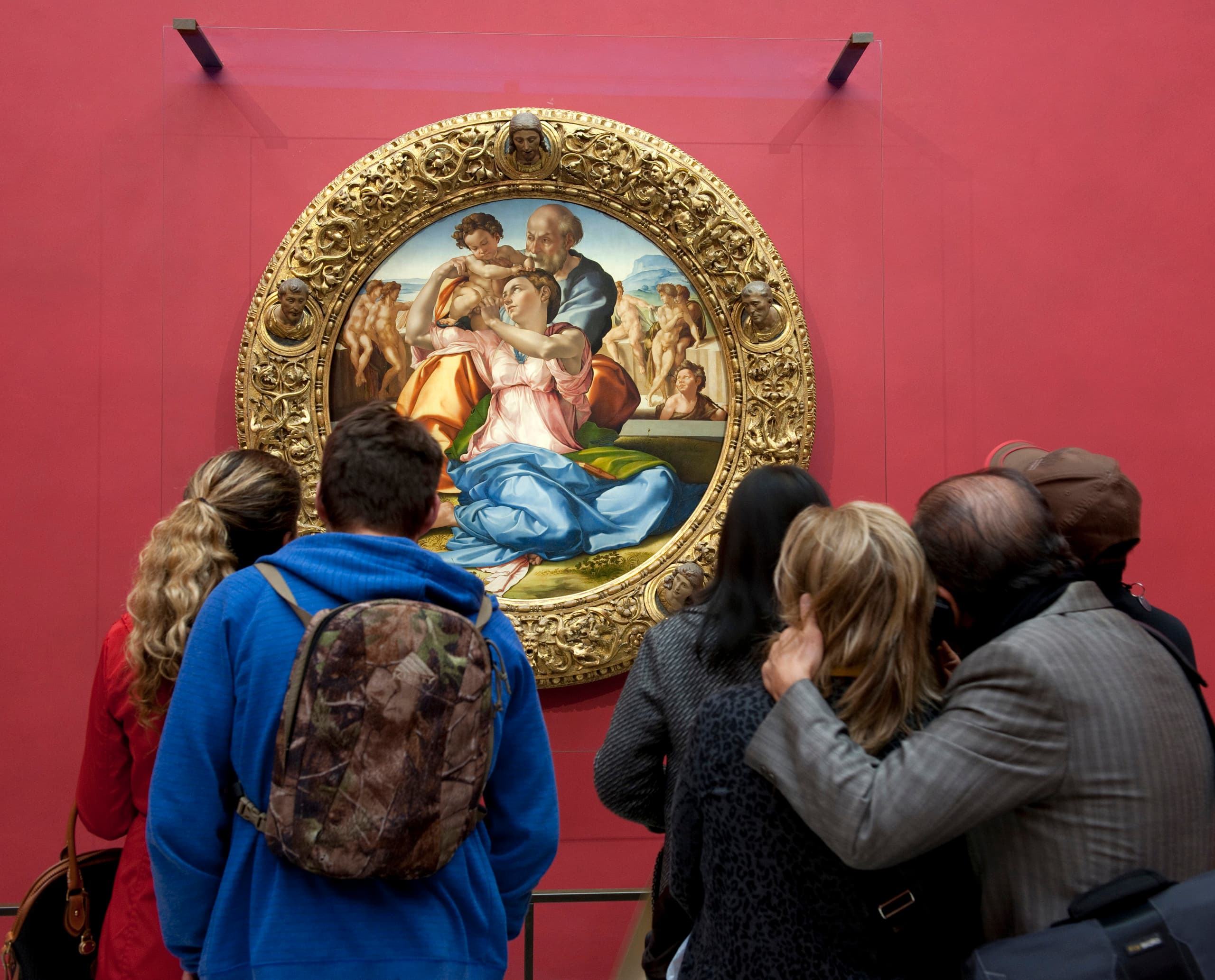 Besucher betrachten ein Gemälde von Raffael in den Uffizien, Florenz.