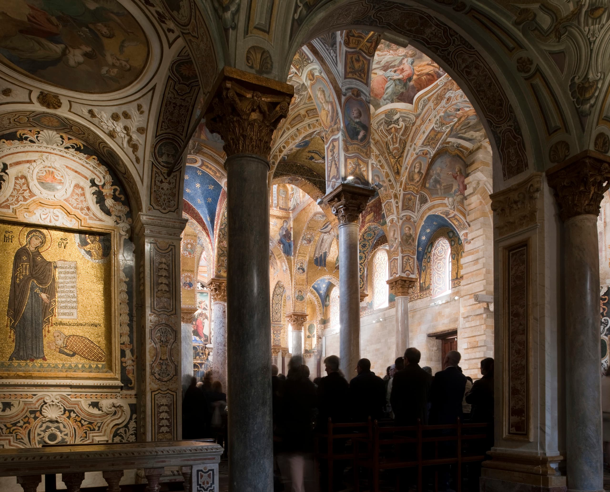 Innenraum der Santa Maria dell’Ammiraglio Kirche in Palermo mit kunstvollen Decken und Besuchern.