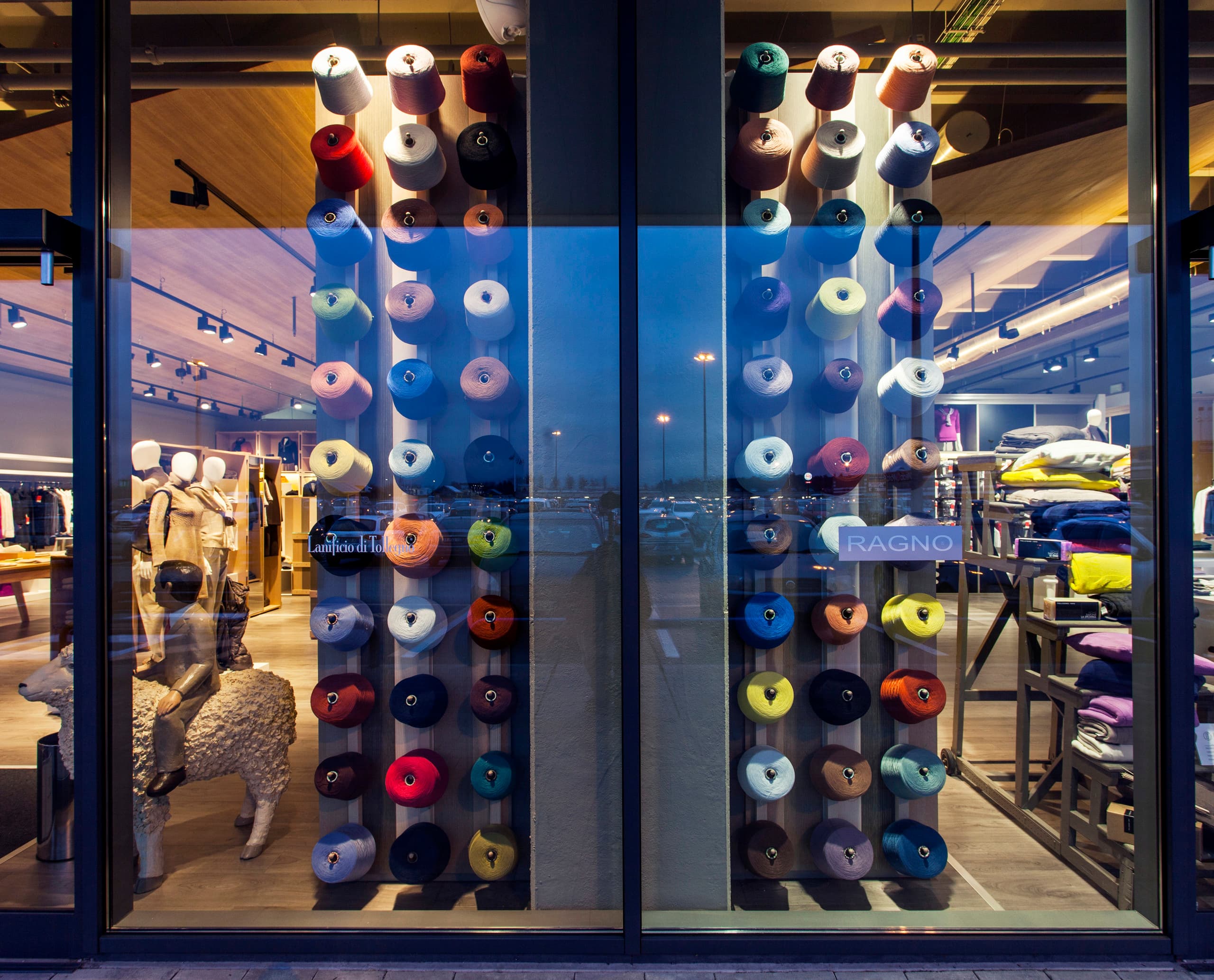 Schaufenster des Lanificio di Tollegno/Ragno Concept Store mit farbigen Garnrollen und ERCO Optec Strahlern.
