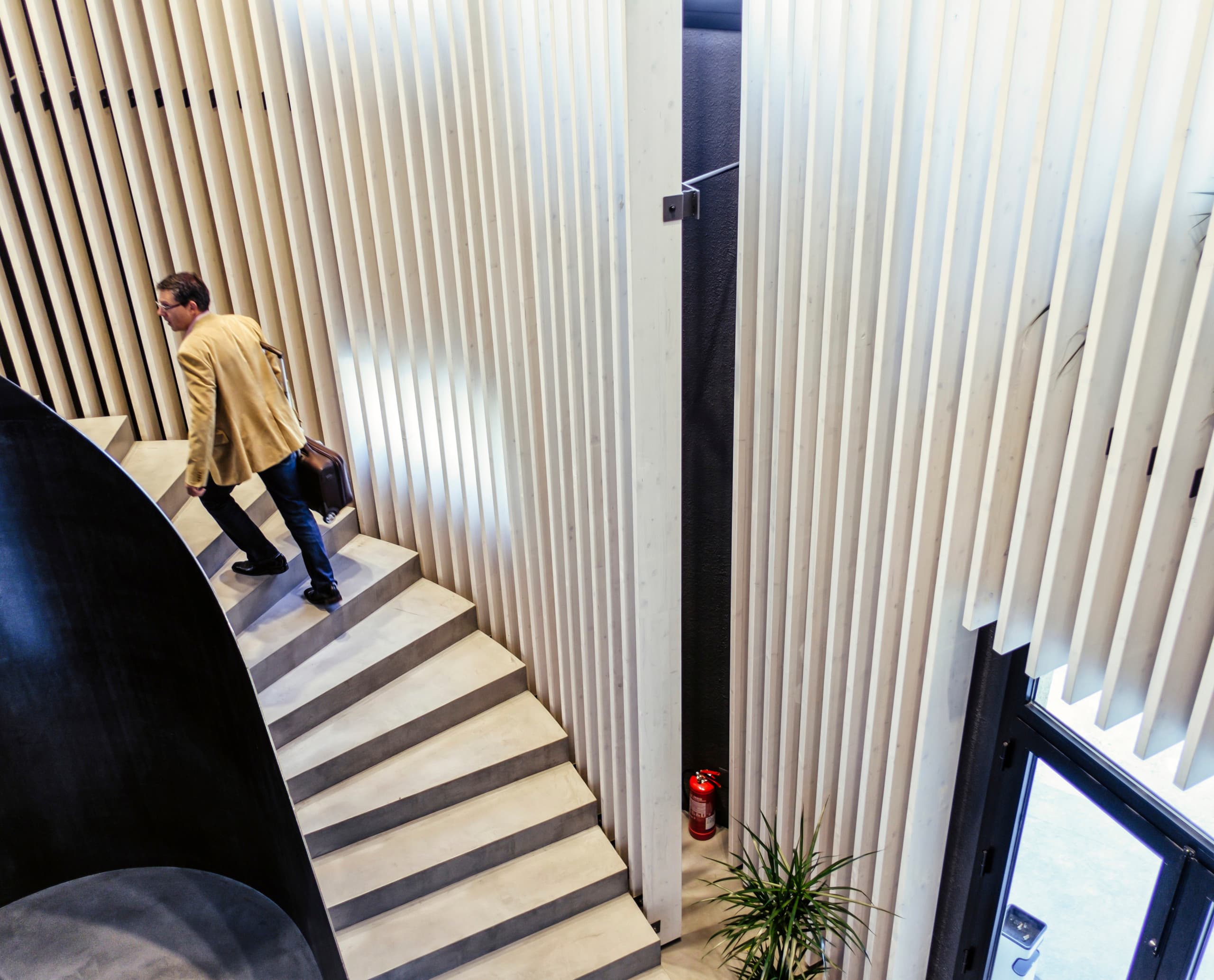 Mann auf Treppe in Graficas Varias mit ERCO LED-Beleuchtung. Modernes Design mit Fokus auf Licht.