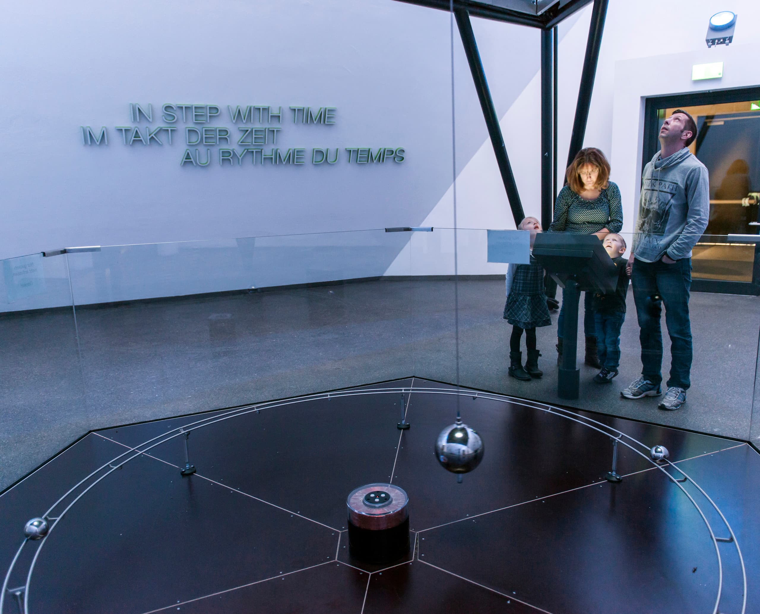 Familie betrachtet Foucaultsches Pendel im Phänomenta Science Center, Lüdenscheid.