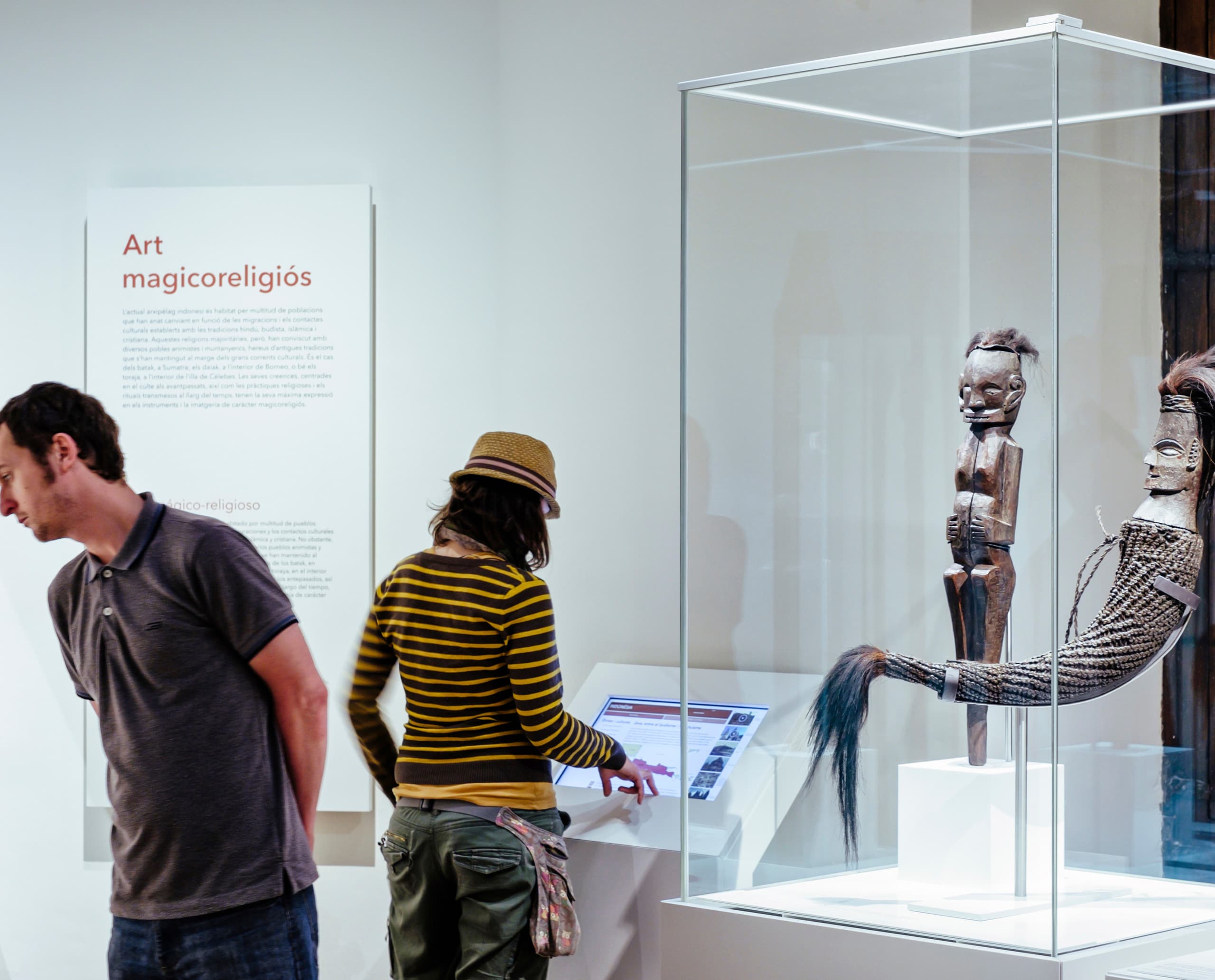 Besucher betrachten Exponate im Museu de Cultures del Món, beleuchtet mit ERCO Optec und Pollux Strahlern.