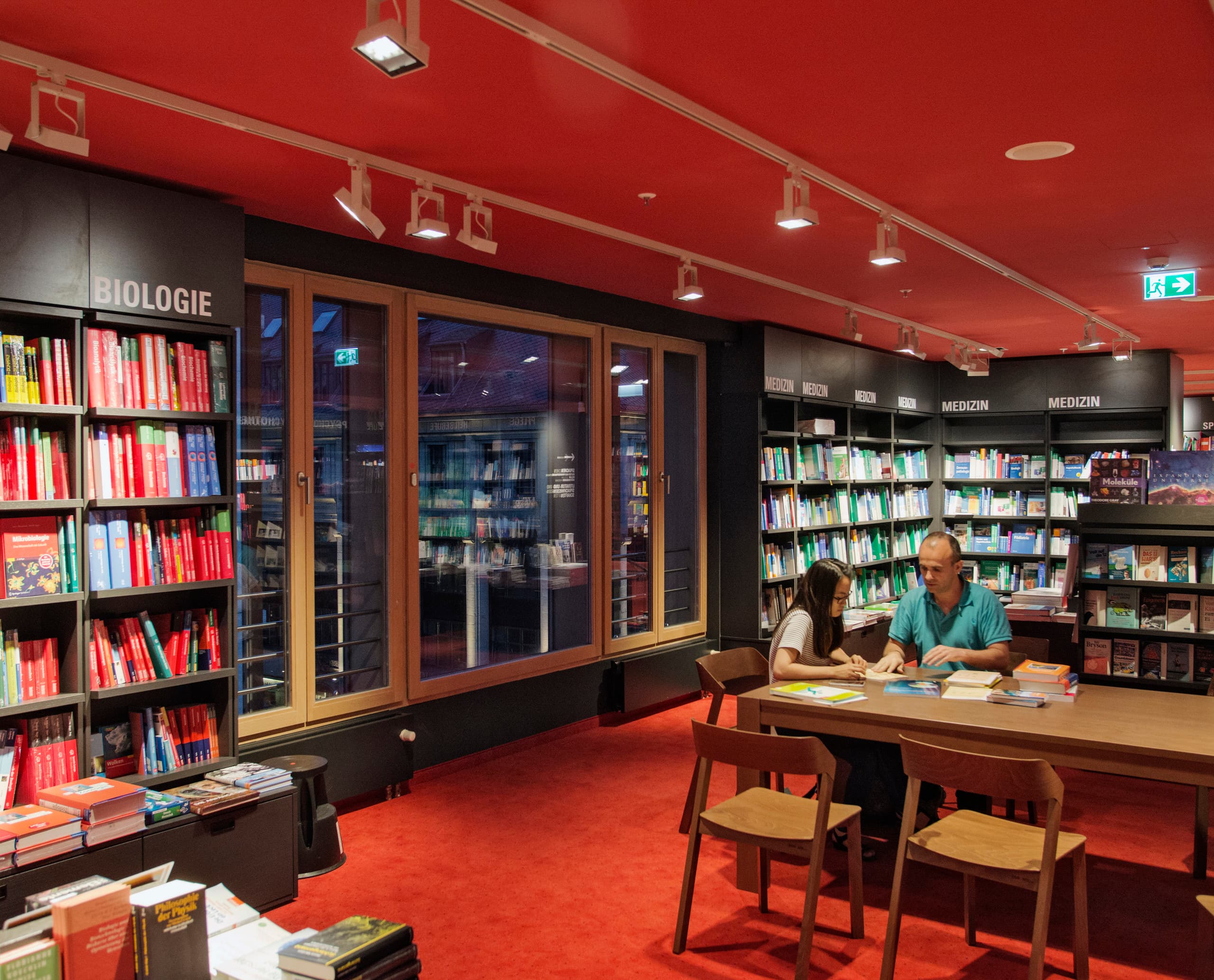 Buchhandlung mit ERCO Lichtdesign: Akzentbeleuchtung der Bücherregale durch Deckenspots.