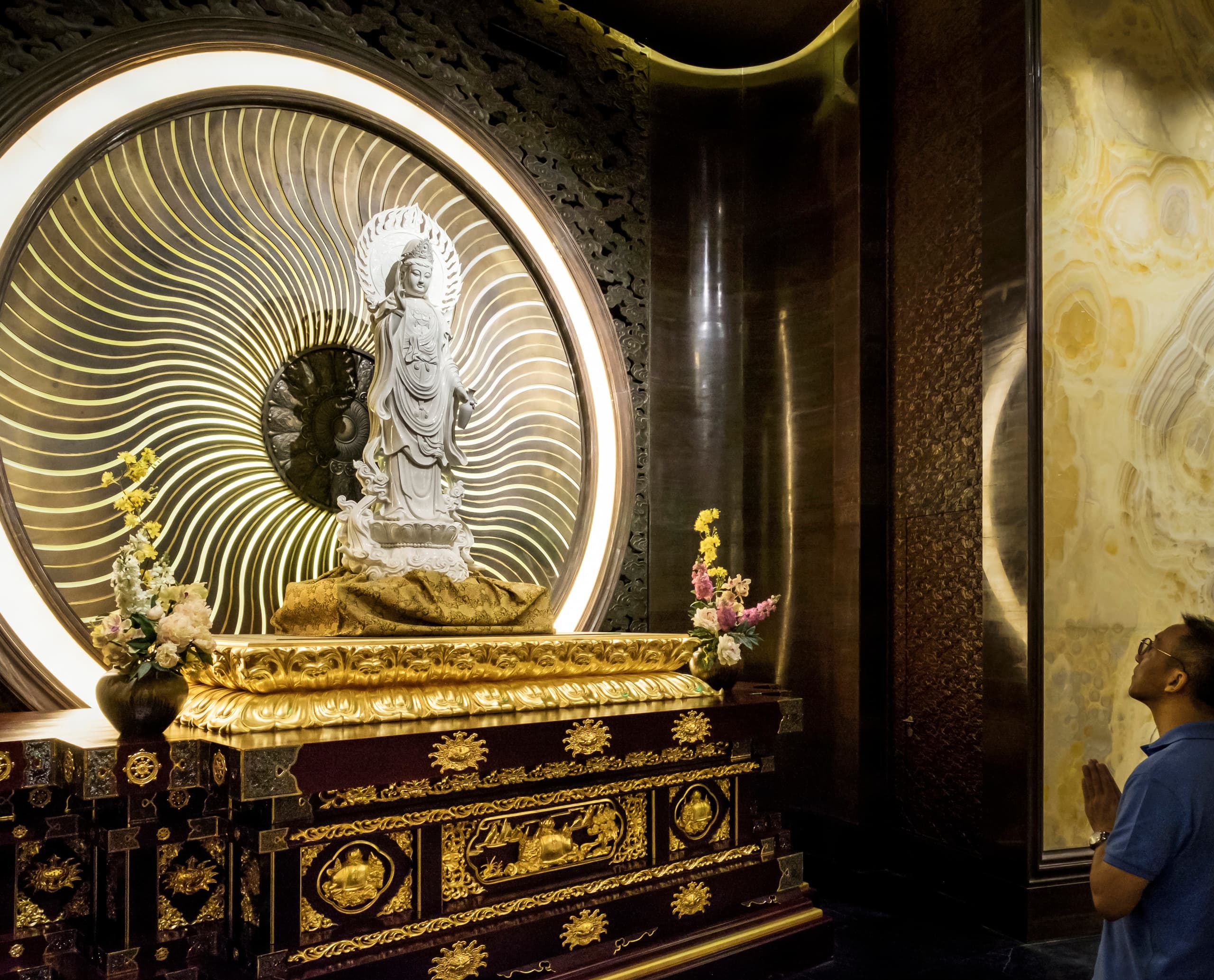 ERCO LED-Beleuchtung im Niushoushan Kulturpark, Nanjing, mit Buddha-Statue und Besucher in Kontemplation.