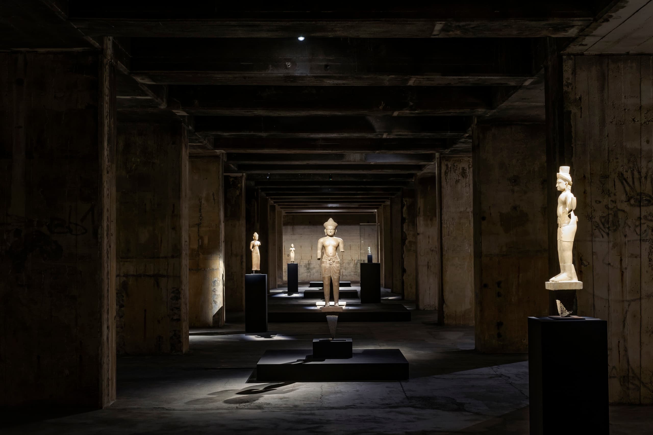 Khmer-Skulpturen in der Feuerle Collection, beleuchtet von ERCO Licht, schaffen eine meditative Atmosphäre in Berlin.