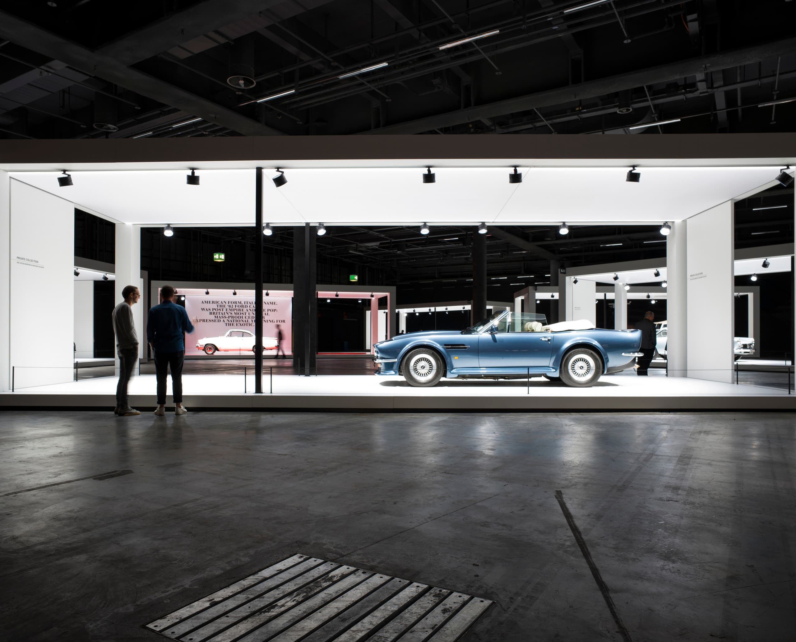 Grand Basel Oldtimer-Ausstellung: Blauer Oldtimer-Cabrio unter ERCO-Beleuchtung in weißem Ausstellungsrahmen.