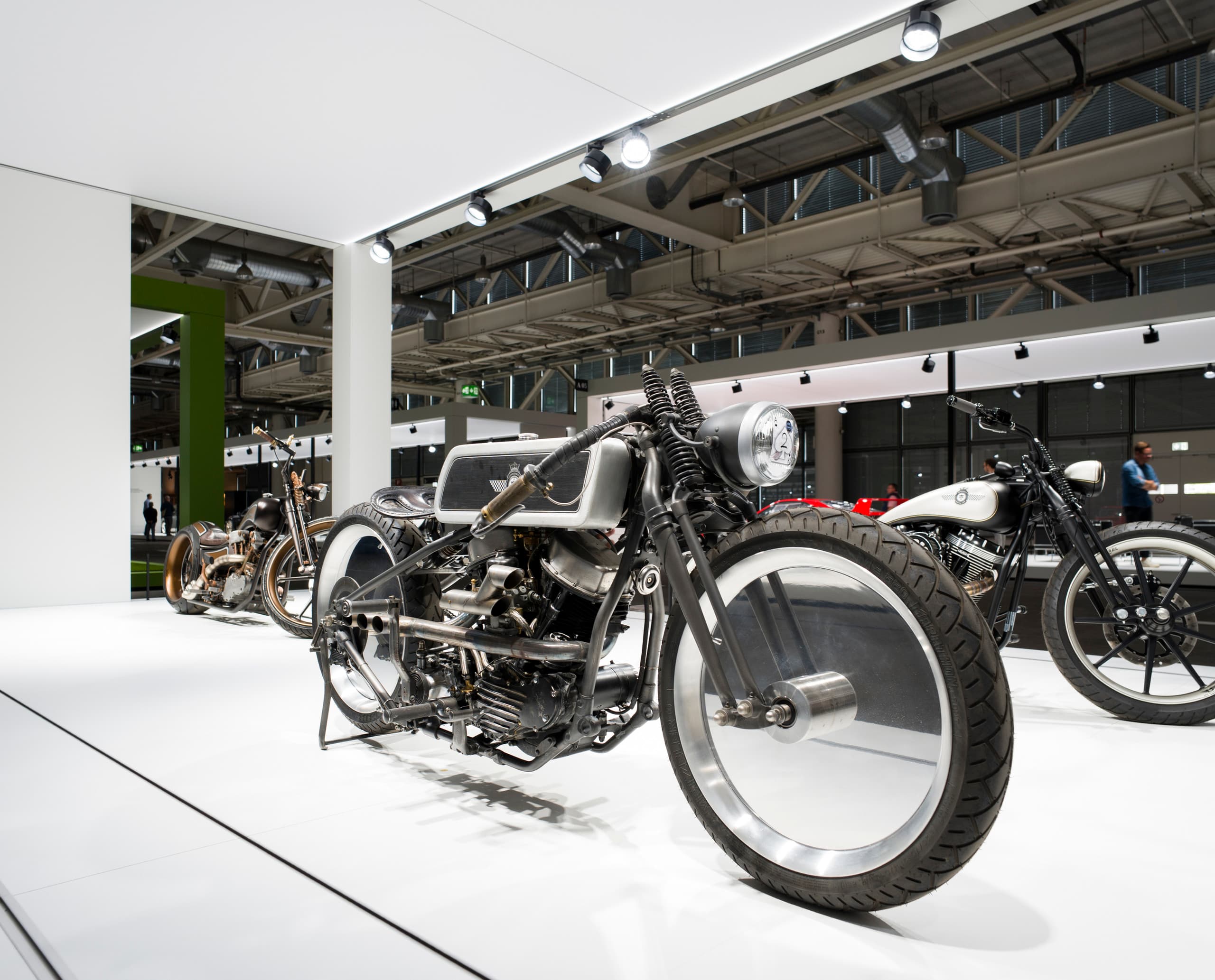 Ausgestellte Oldtimer-Motorräder unter ERCO-Beleuchtung auf der Grand Basel, die die Ästhetik und den Wert der Fahrzeuge hervorhebt.