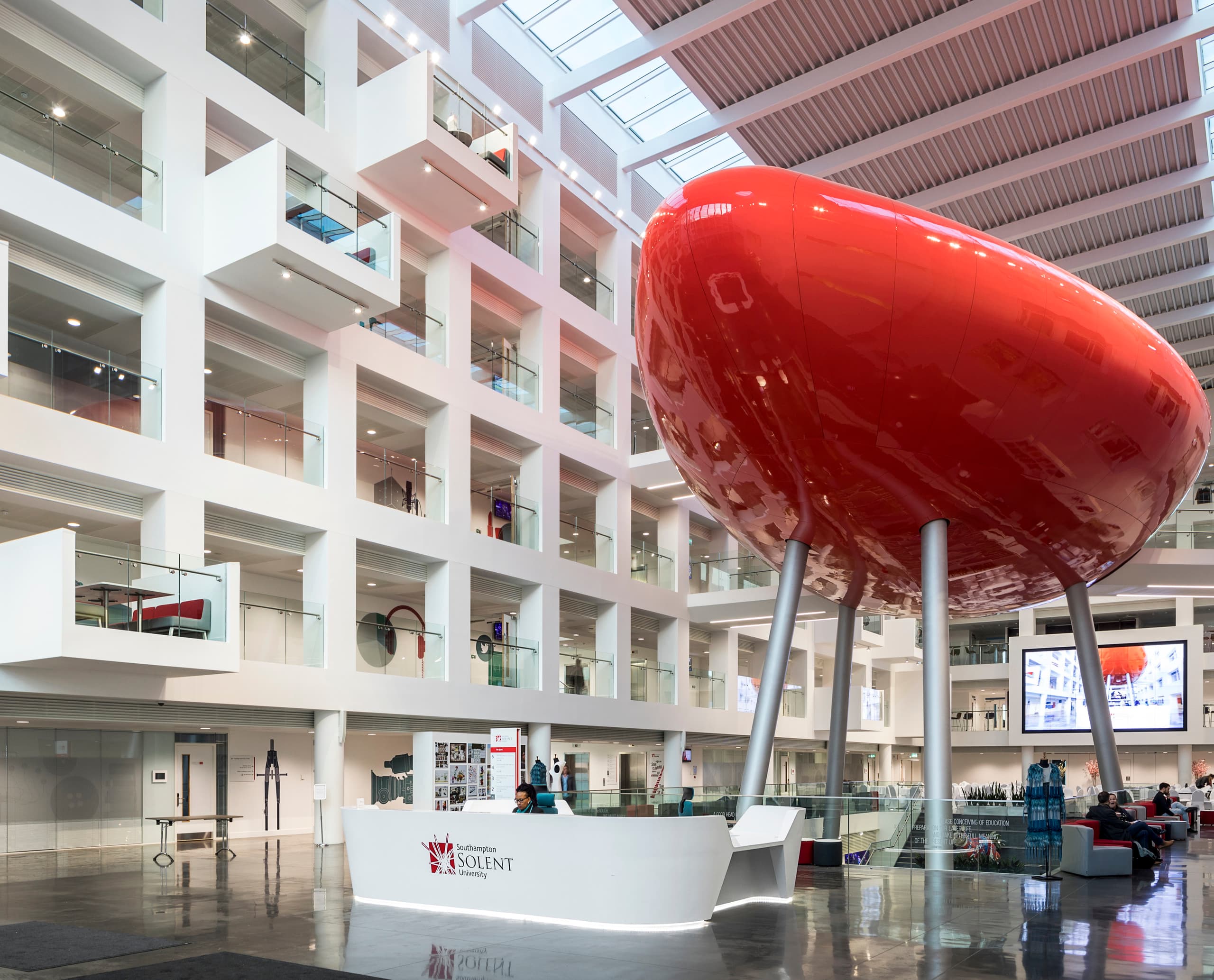 Spark Building, Solent University: Empfangsbereich mit markanter roter Skulptur und ERCO LED-Beleuchtung.