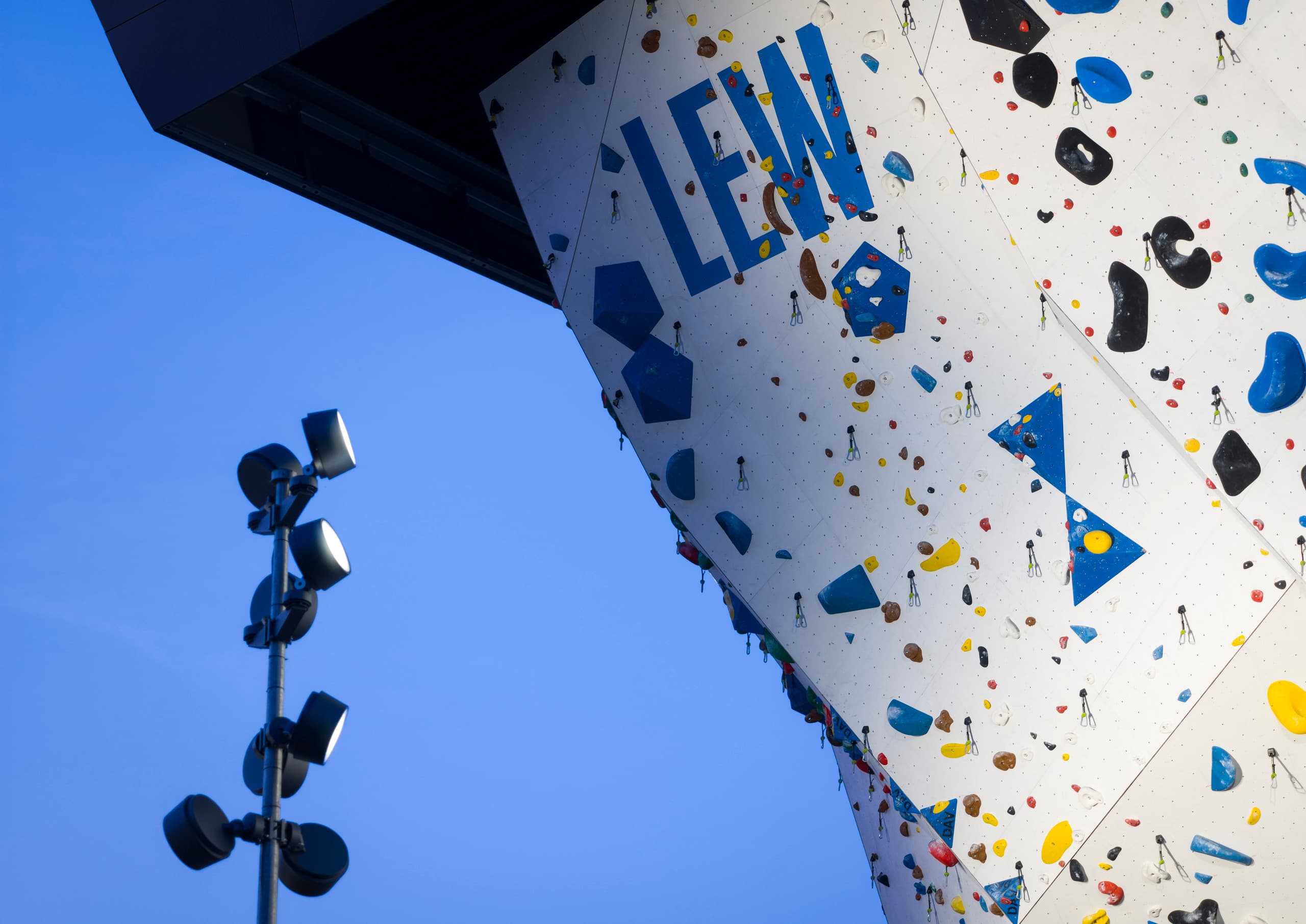 Beleuchteter Kletterturm mit LED-Strahlern, die die Griffe hervorheben und für Sicherheit sorgen.