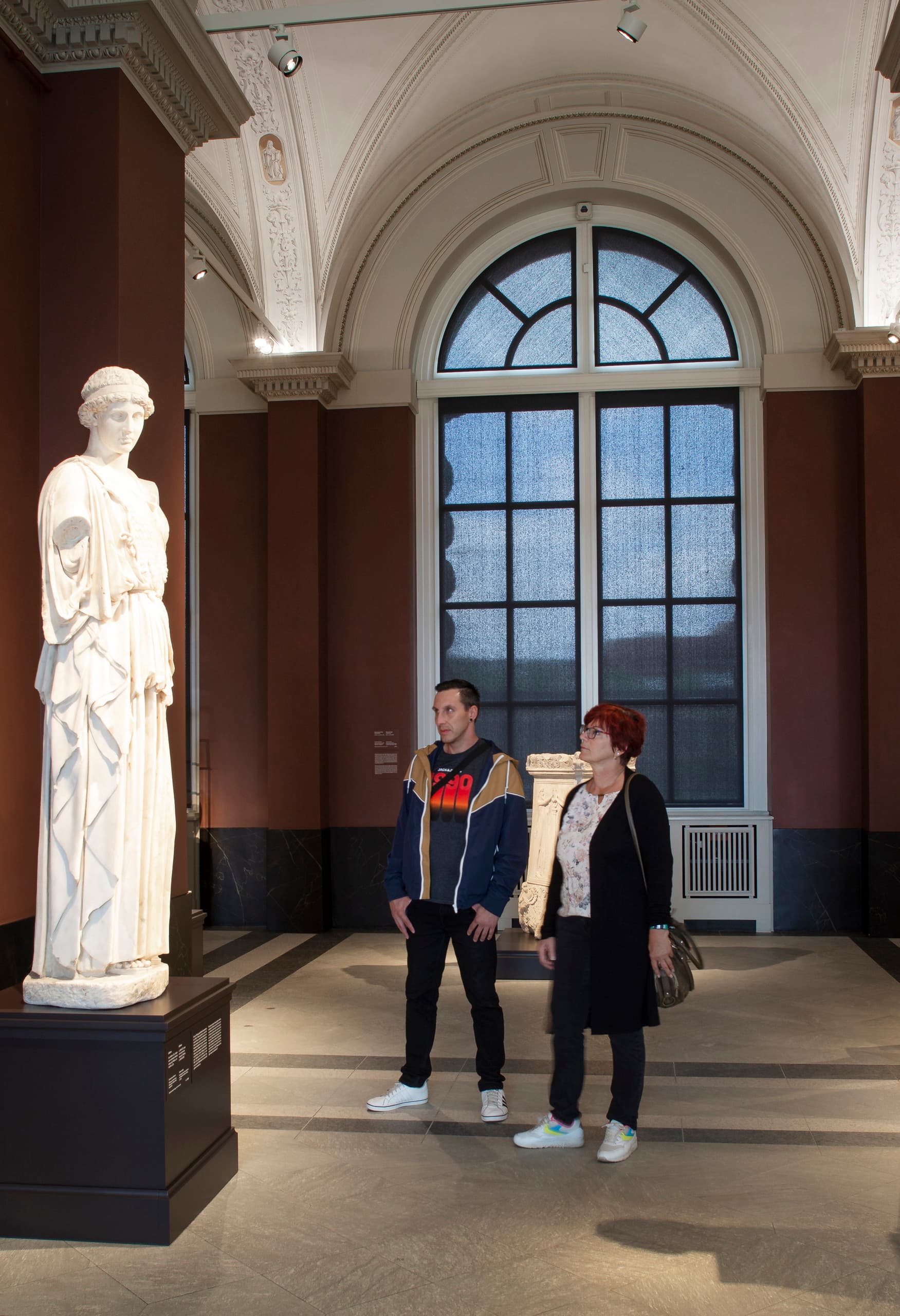 Besucher betrachten eine Skulptur, beleuchtet von ERCO LED-Strahlern in der Gemäldegalerie Alte Meister.