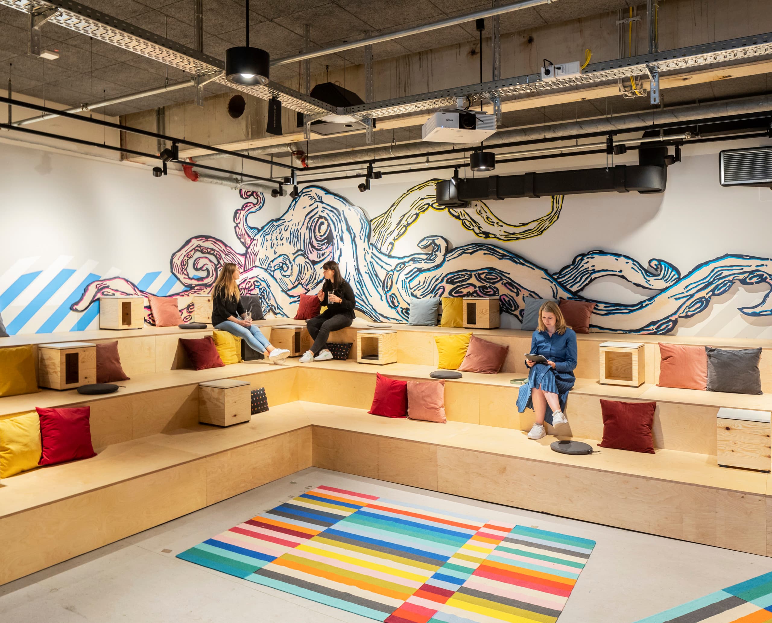 Flexibles ERCO LED-Licht in einem Co-Working Space mit anpassbaren Arbeitsbereichen und Jilly Downlights.