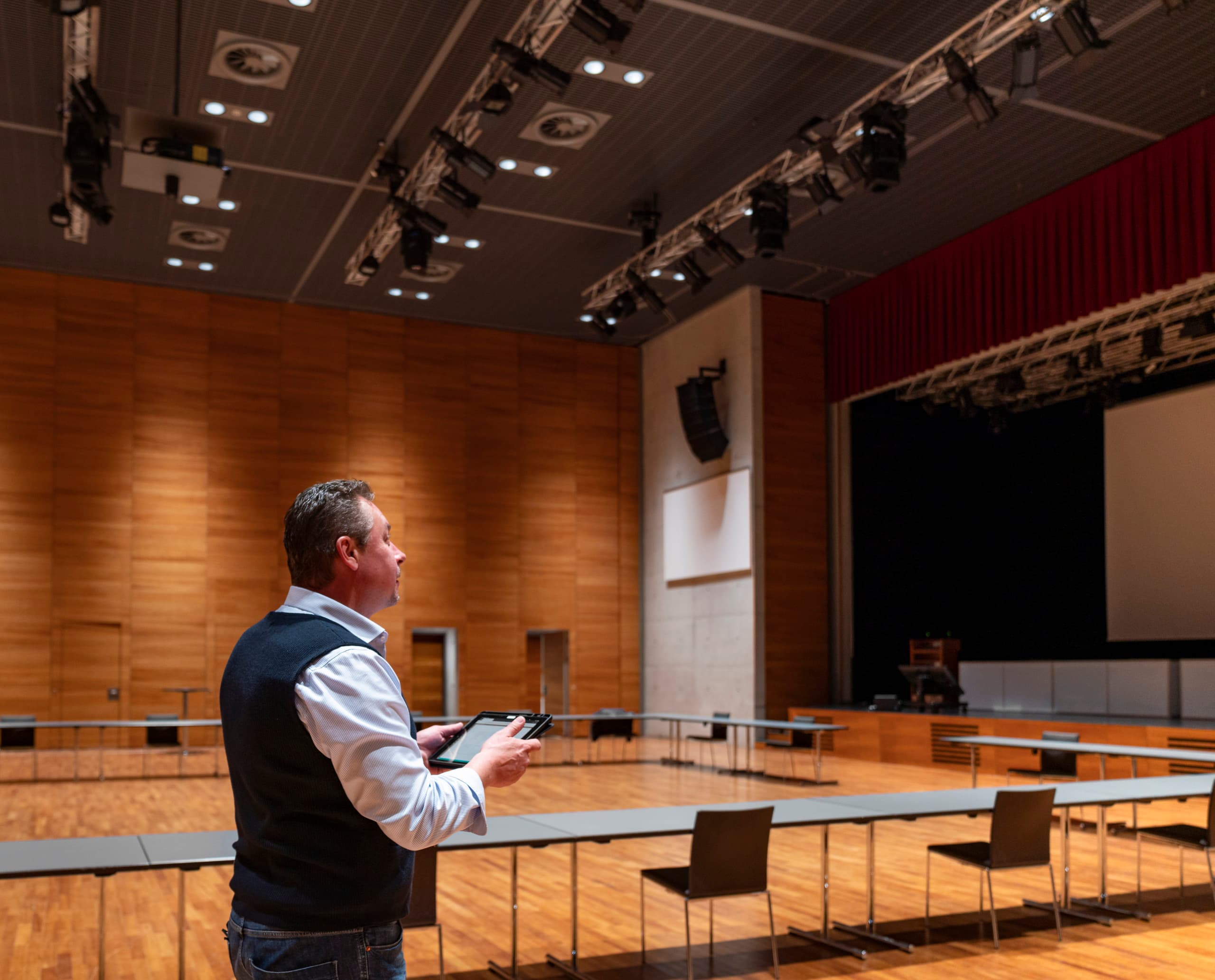 Mann mit Tablet im Ferry Porsche Congress Center, Zell am See. ERCO LED-Beleuchtung für Energieeffizienz.
