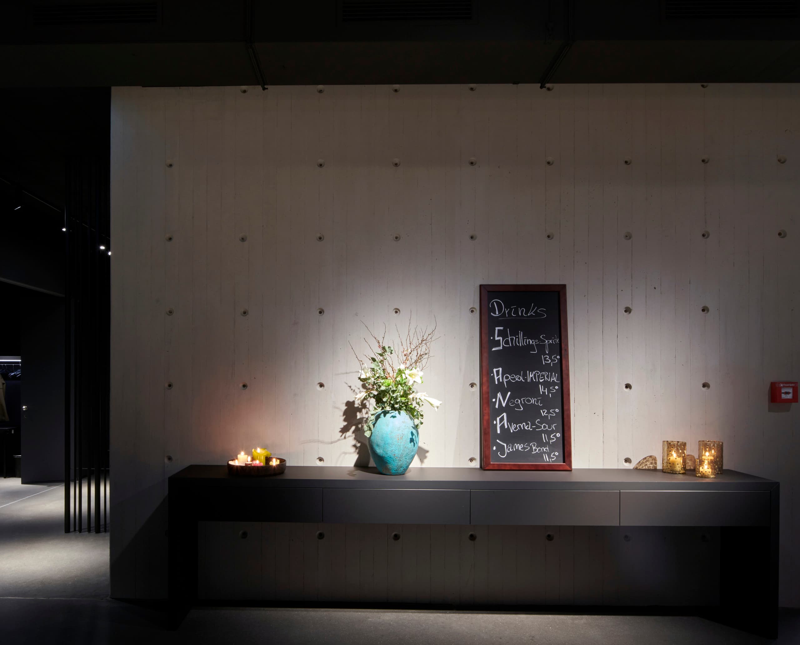 Schauspielhaus Düsseldorf: Beleuchtete Bar mit Getränkekarte und Blumenvase, Teil der LED-Relighting-Lösung von ERCO.