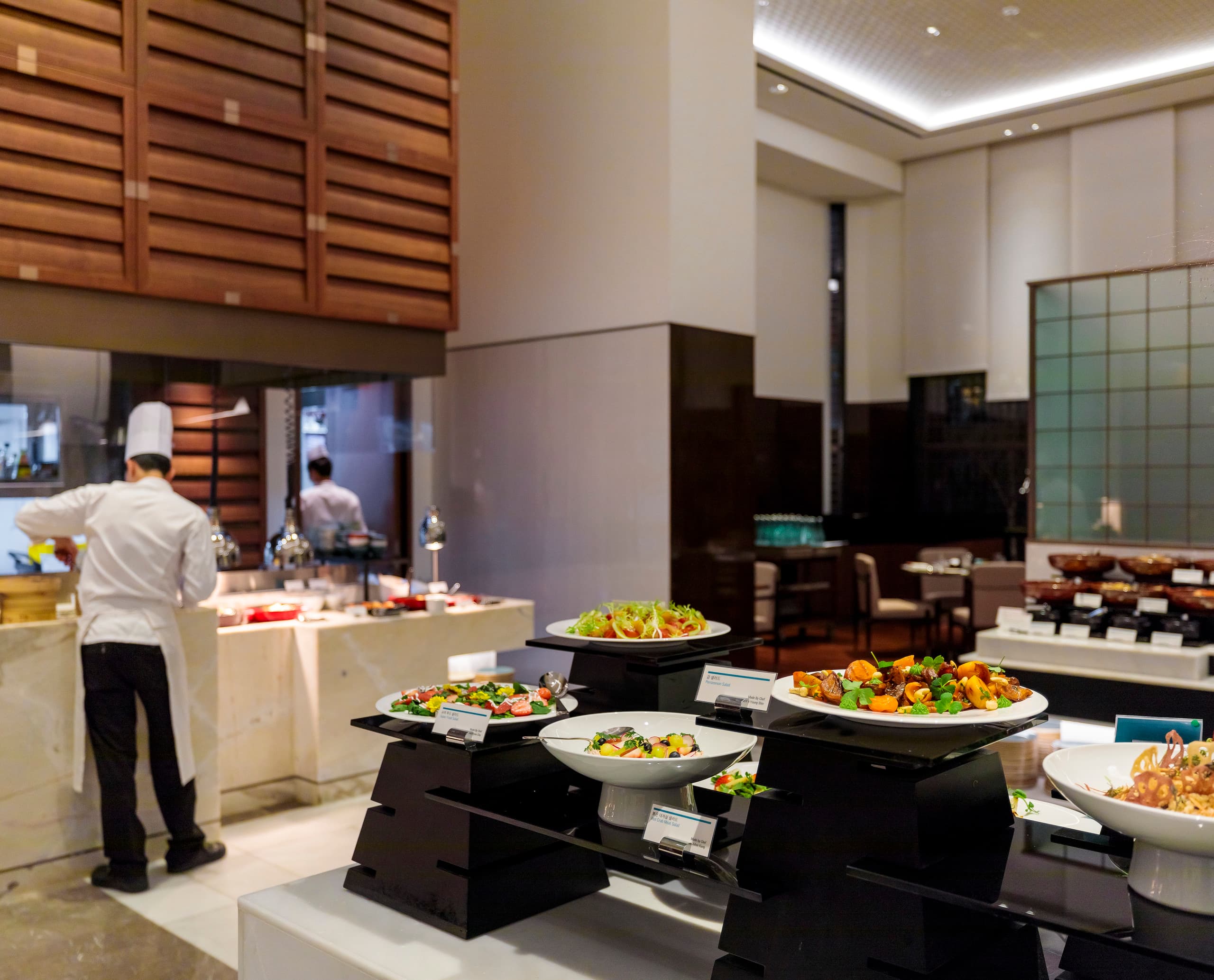 Buffet im Le Méridien Seoul mit Salaten und warmen Speisen, beleuchtet mit ERCO Strahlern für einladende Atmosphäre.