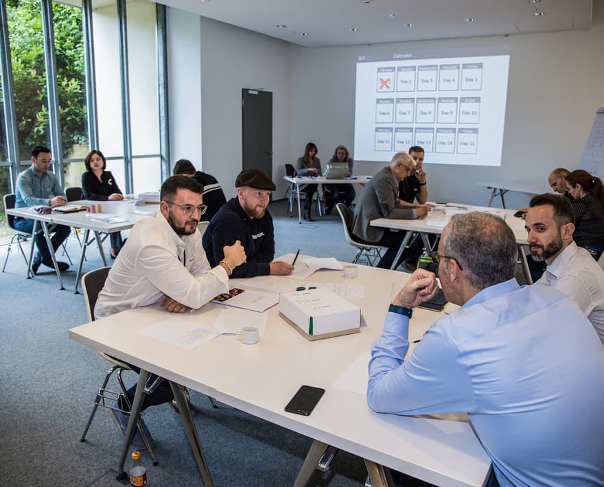 ERCO Vertriebsteam-Meeting: Vertriebsmitarbeiter besprechen Lichtlösungen in einem hellen Konferenzraum.
