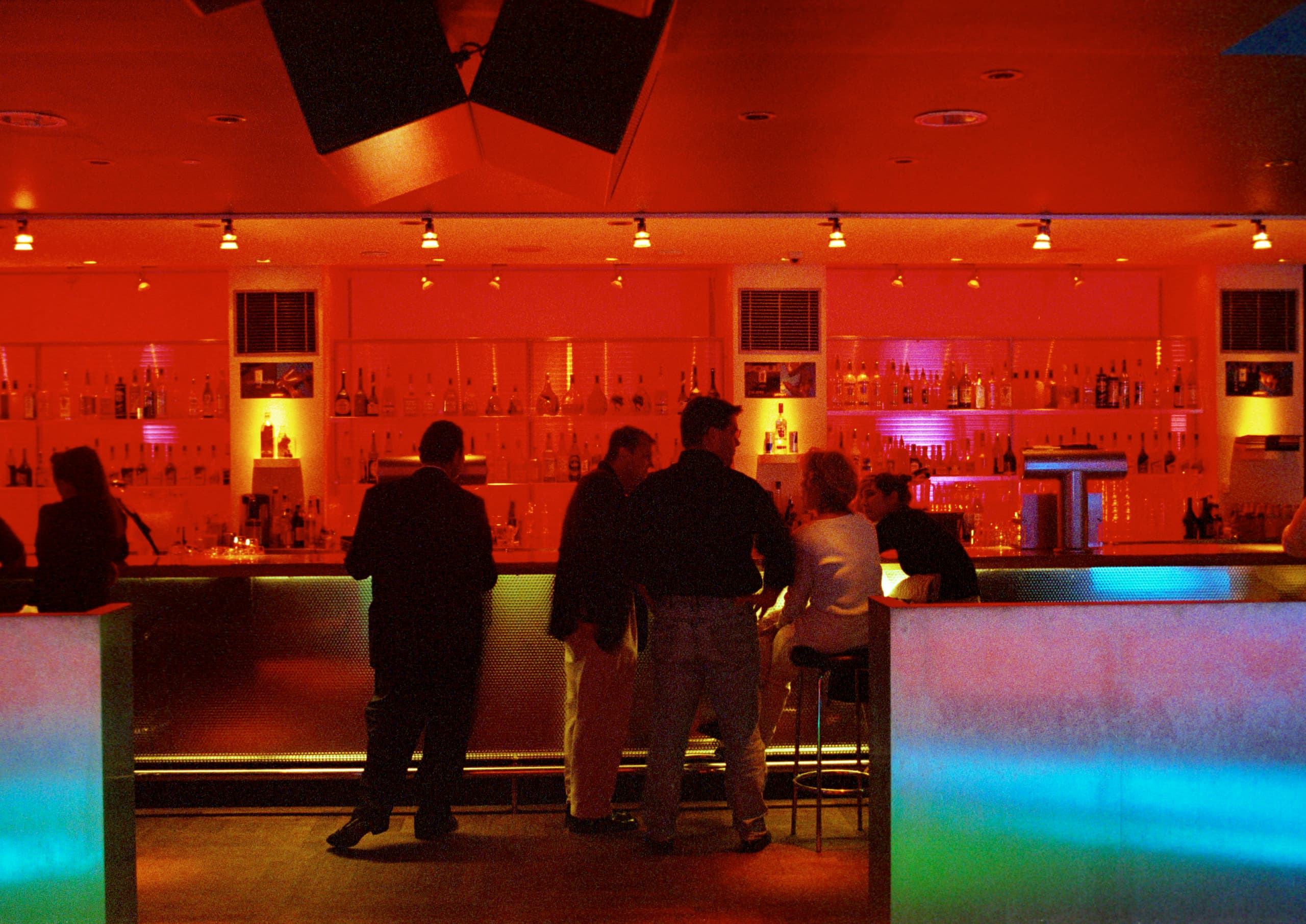 Rote Farbwirkung in einer Bar, die eine warme und energetische Atmosphäre durch ERCO Beleuchtung erzeugt.