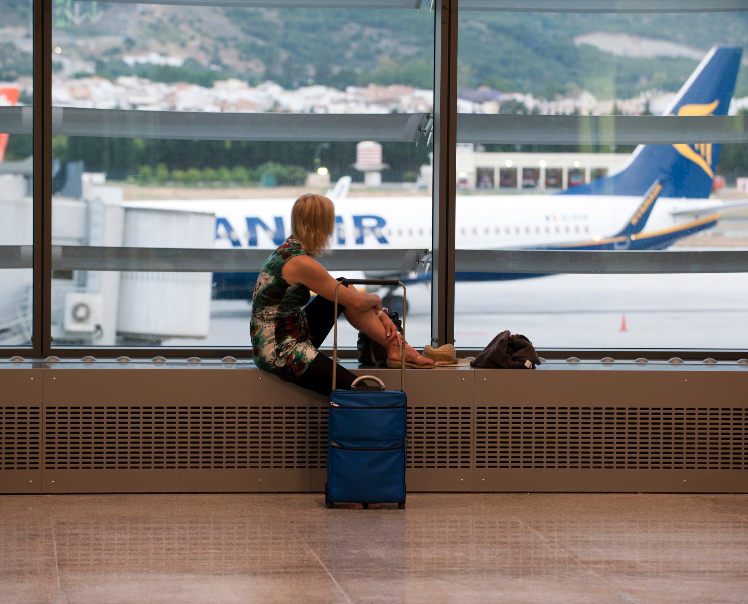 Reisende wartet am Malaga Airport Terminal 3 mit ERCO Licht auf ihren Flug.