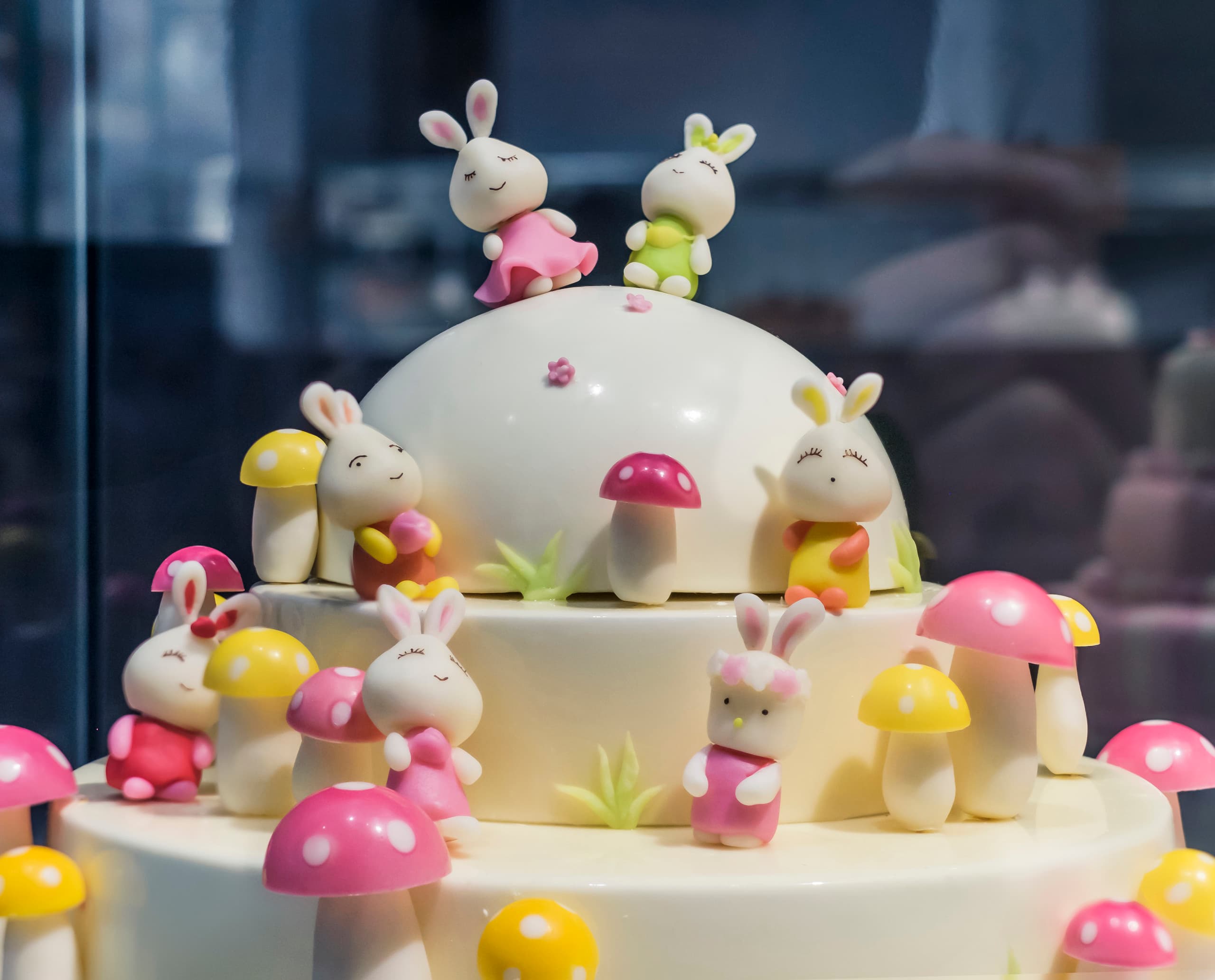 Dekorativer Kuchen mit Hasenfiguren und Pilzen, beleuchtet mit ERCO Optec Strahlern in der Black Swan Patisserie, Peking.