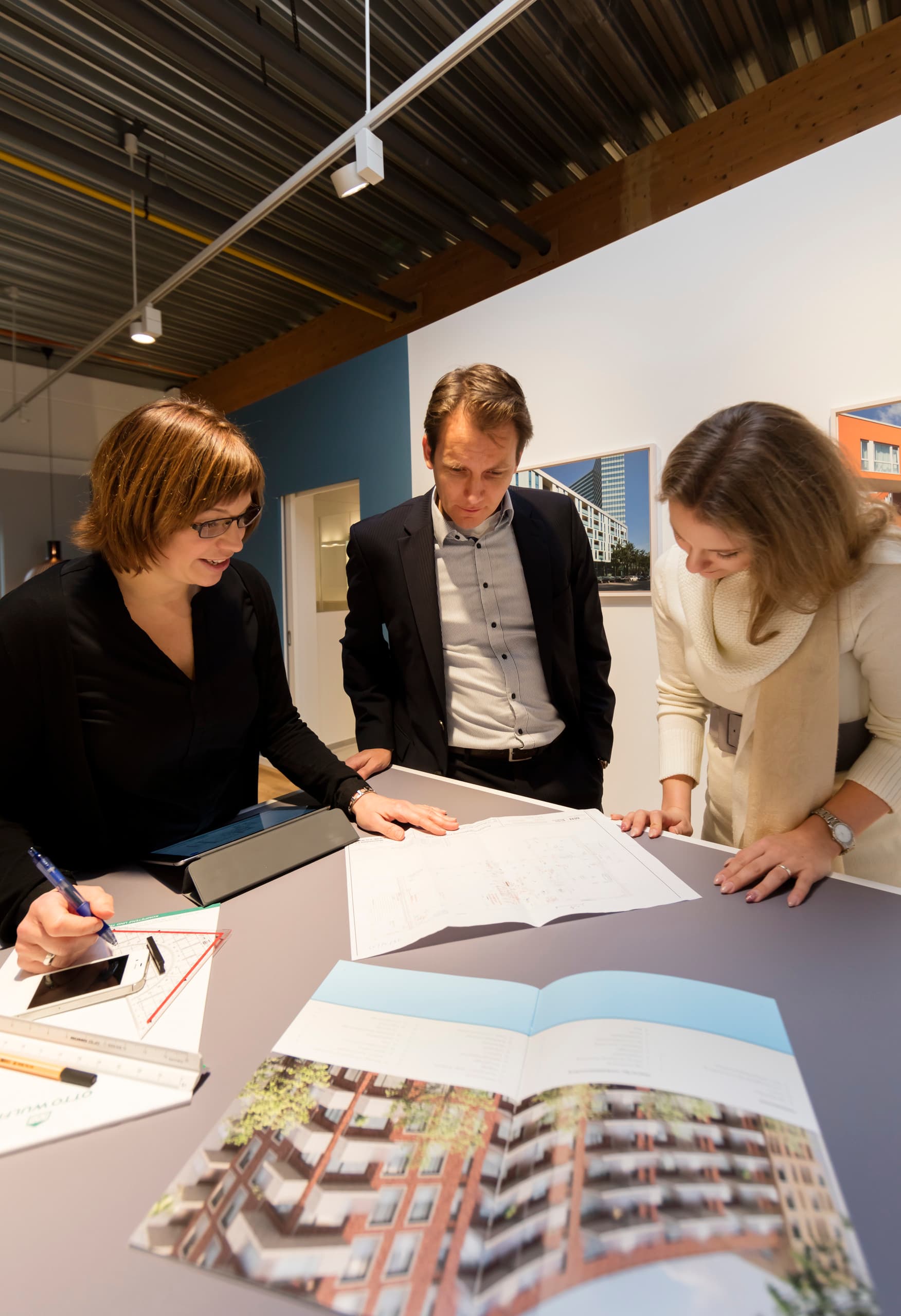 Otto Wulff Projektteam bespricht Baupläne im Showroom, beleuchtet mit ERCO LED-Leuchten für optimale Farbwiedergabe.