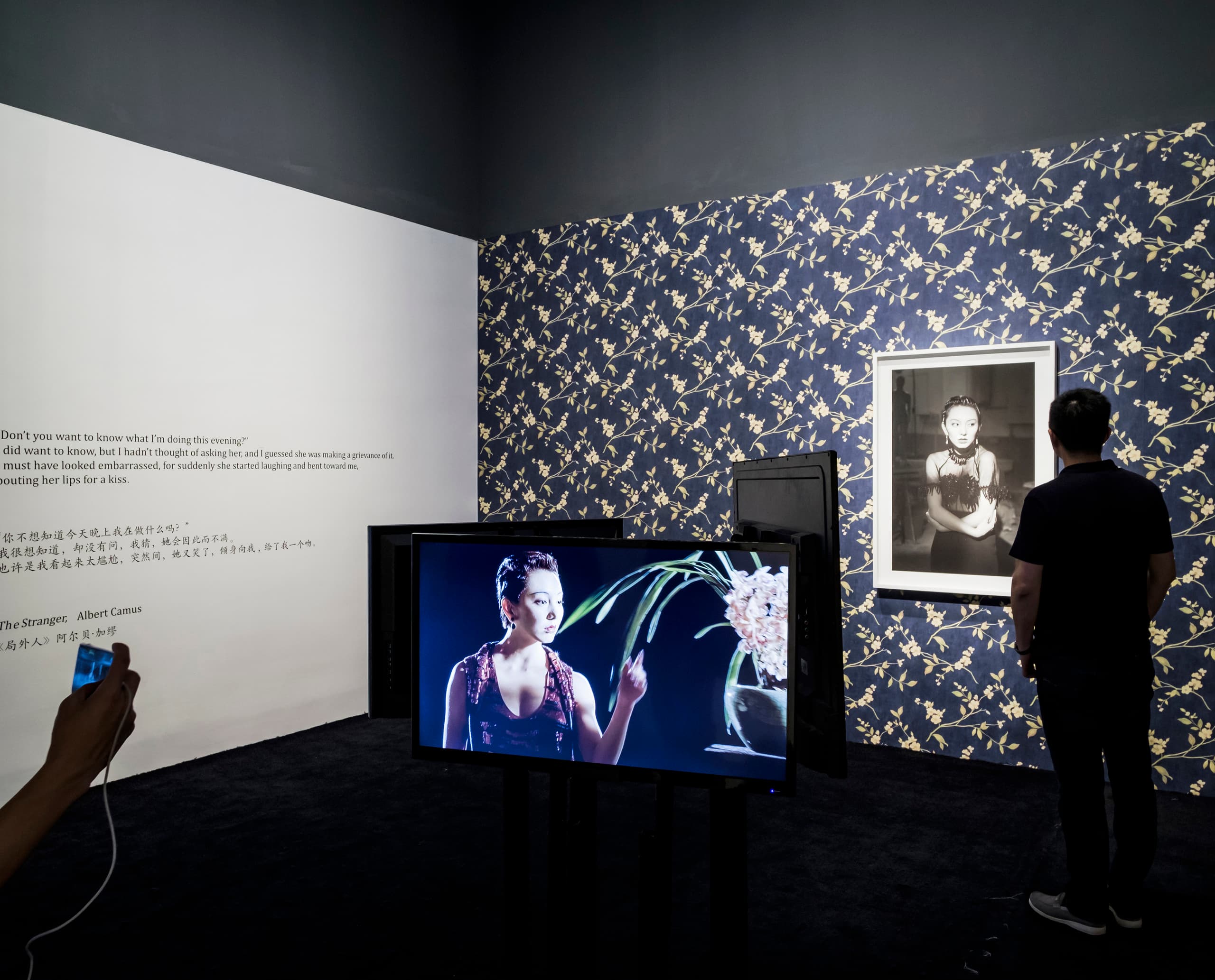 Kunstausstellung mit Akzentbeleuchtung, die Gemälde und Videokunst hervorhebt.