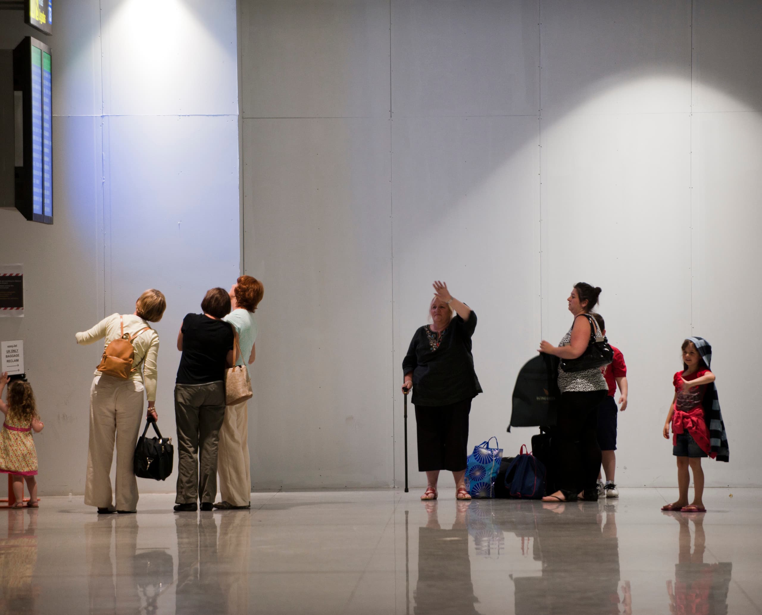 Flughafen Málaga Terminal 3: Reisende unter ERCO Downlights, die für effizienten visuellen Komfort sorgen.