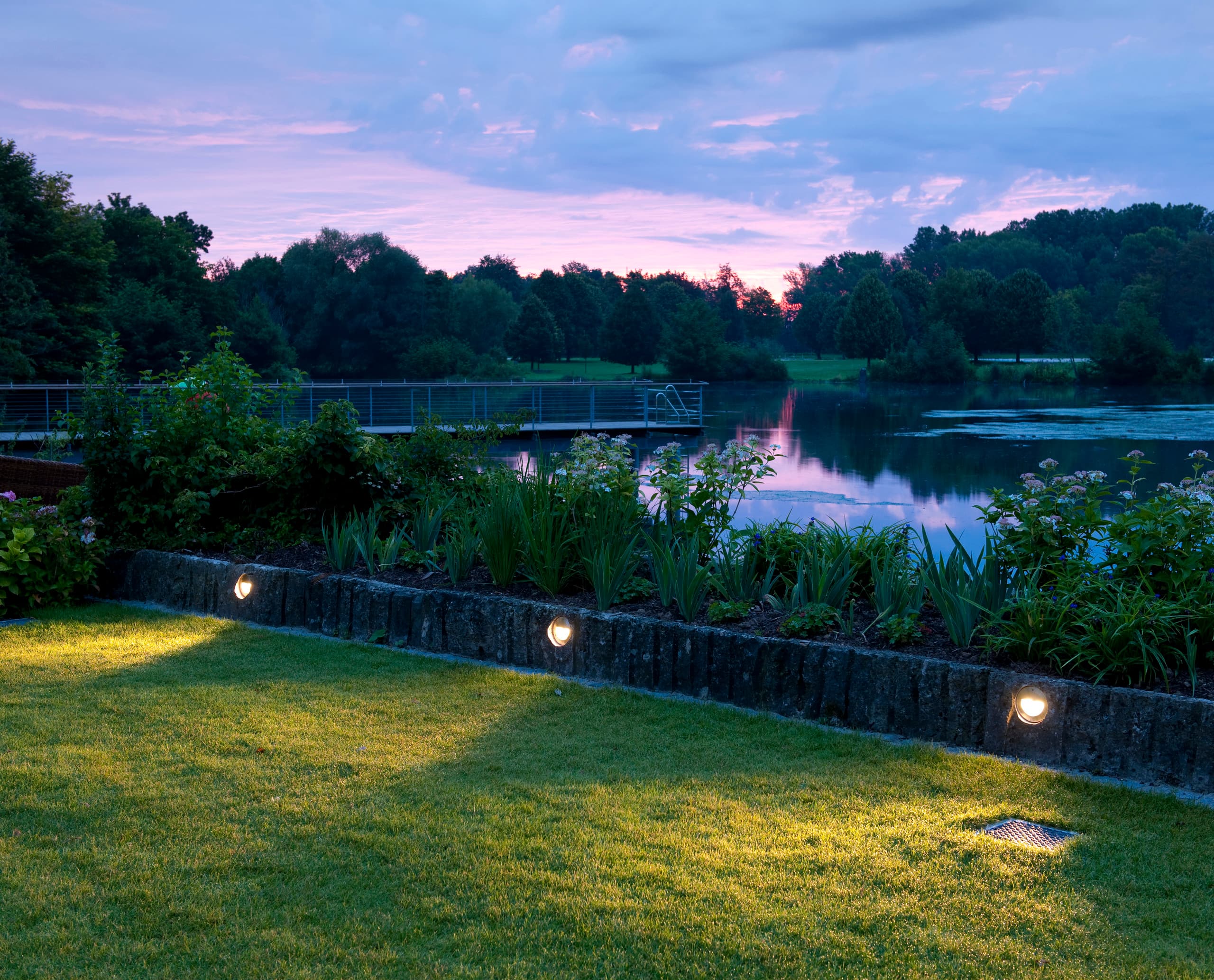 ERCO LED-Leuchten am LAGO Hotel in Ulm beleuchten den Garten am Seeufer und schaffen eine entspannende Atmosphäre.
