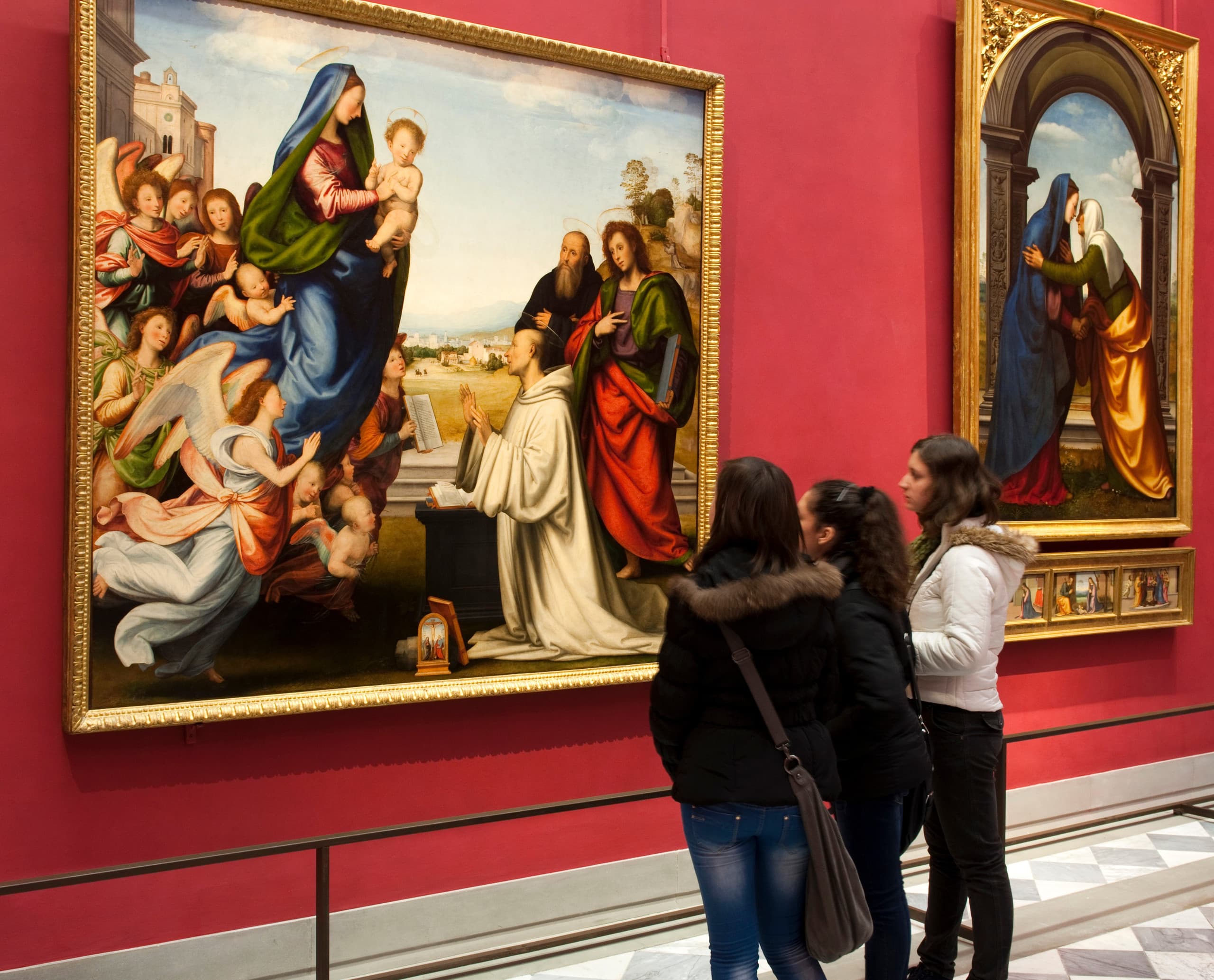 Besucher betrachten ein Gemälde in den Uffizien, Florenz. Kunstausstellung mit Beleuchtung.