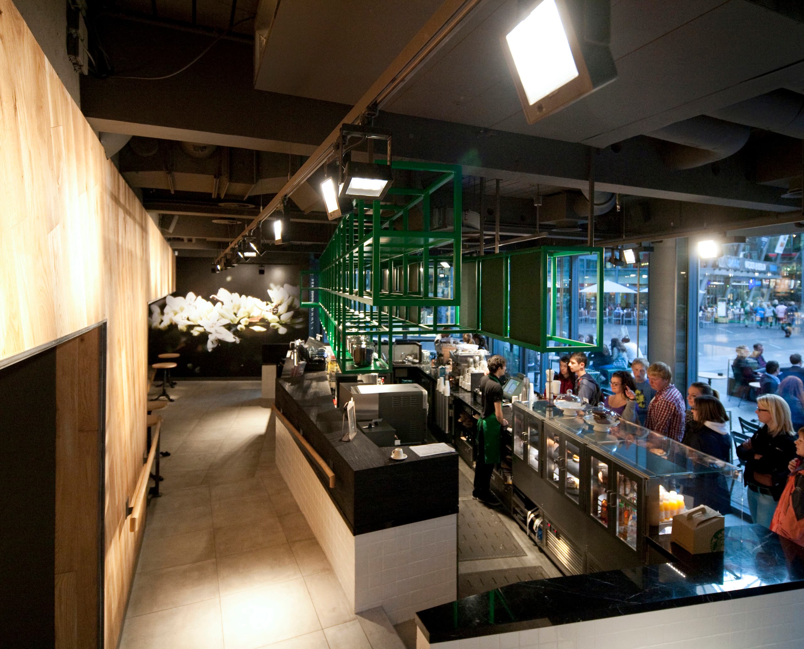 Innenansicht des Starbucks Coffee House in Berlin mit ERCO LED-Beleuchtung für einladende Atmosphäre.