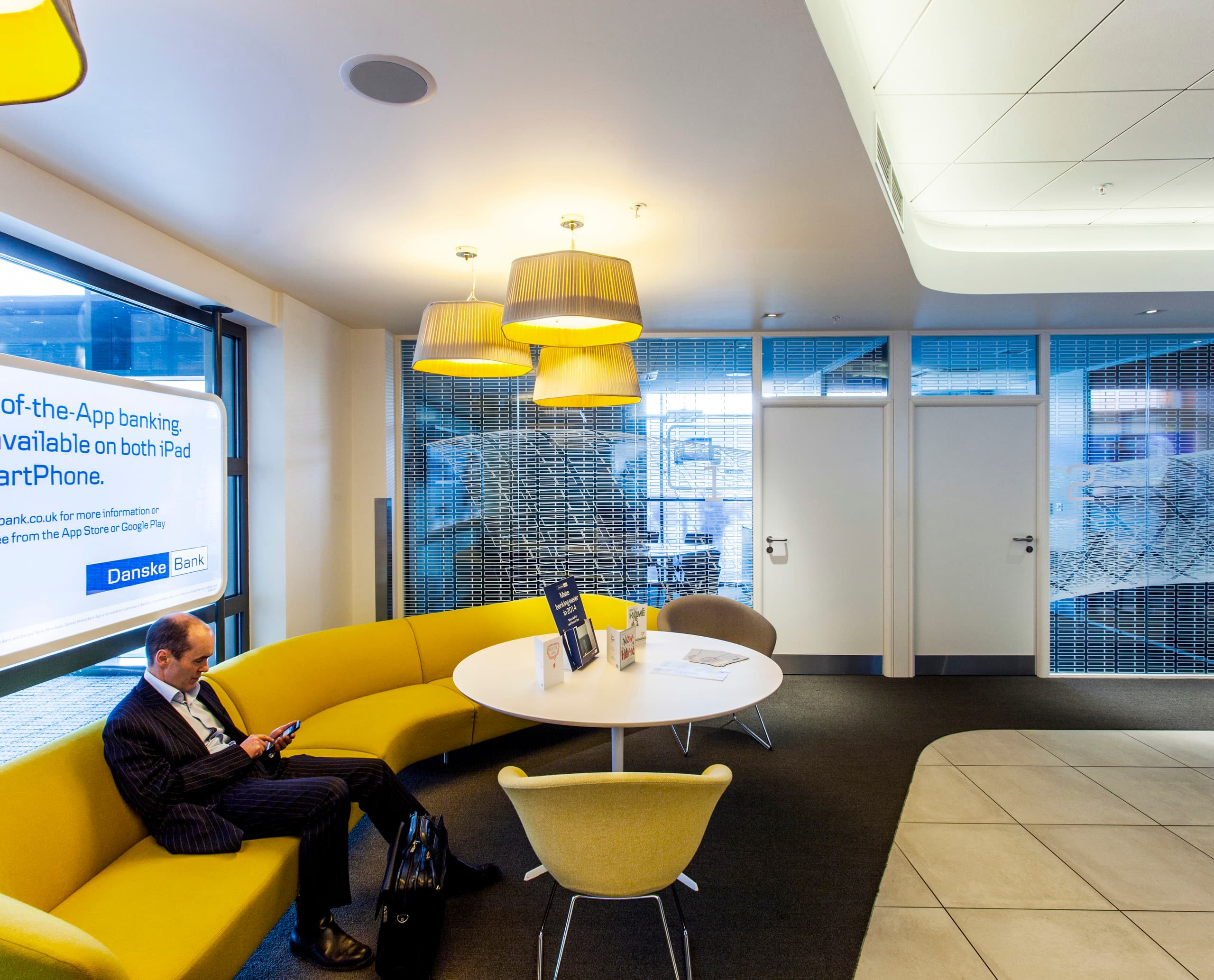 Danske Bank Filiale Belfast: Einladender Wartebereich mit LED-Beleuchtung und App-Werbung.