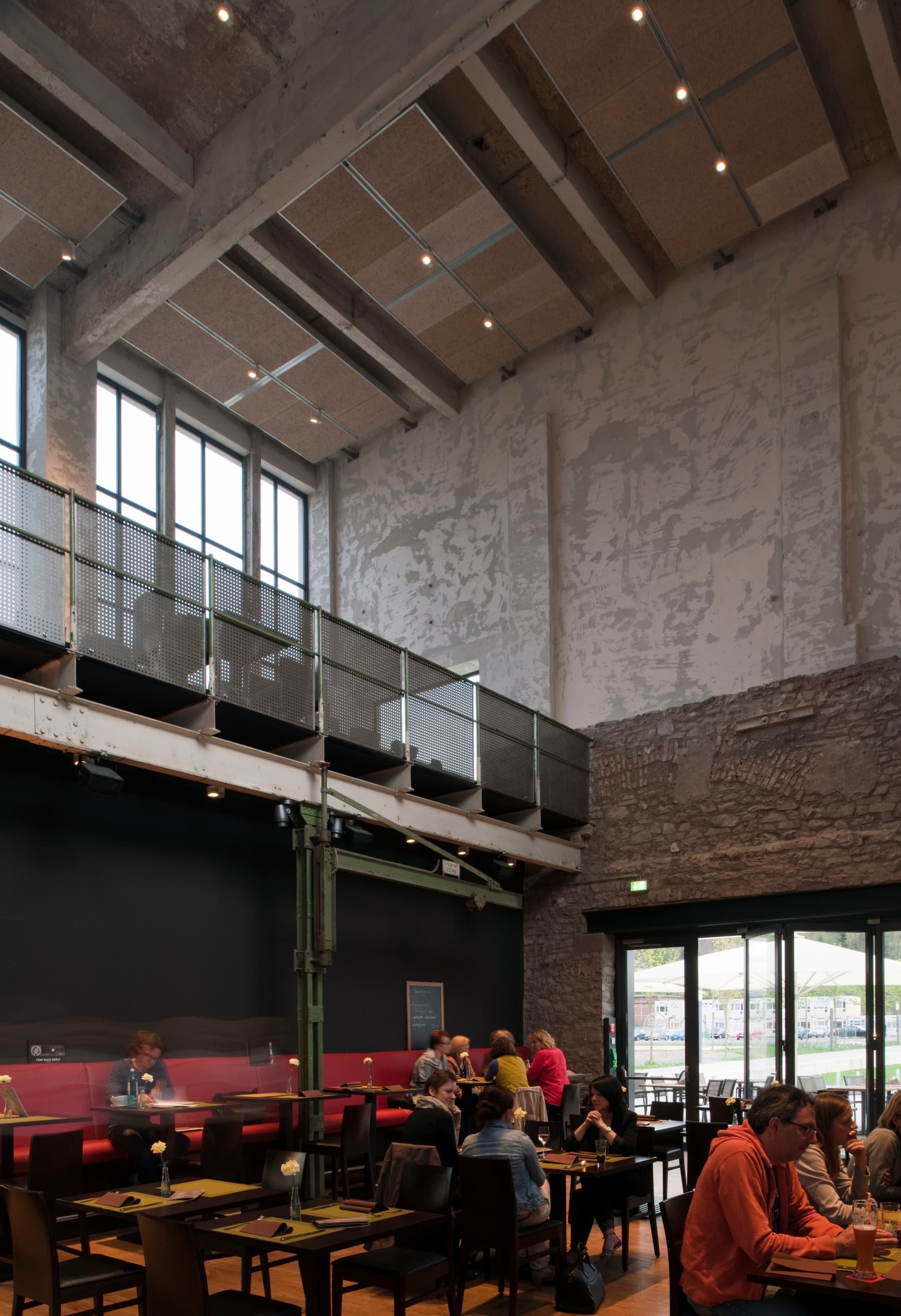 Halle 32 Restaurant in Gummersbach mit ERCO Optec Strahlern, die die industrielle Architektur hervorheben.
