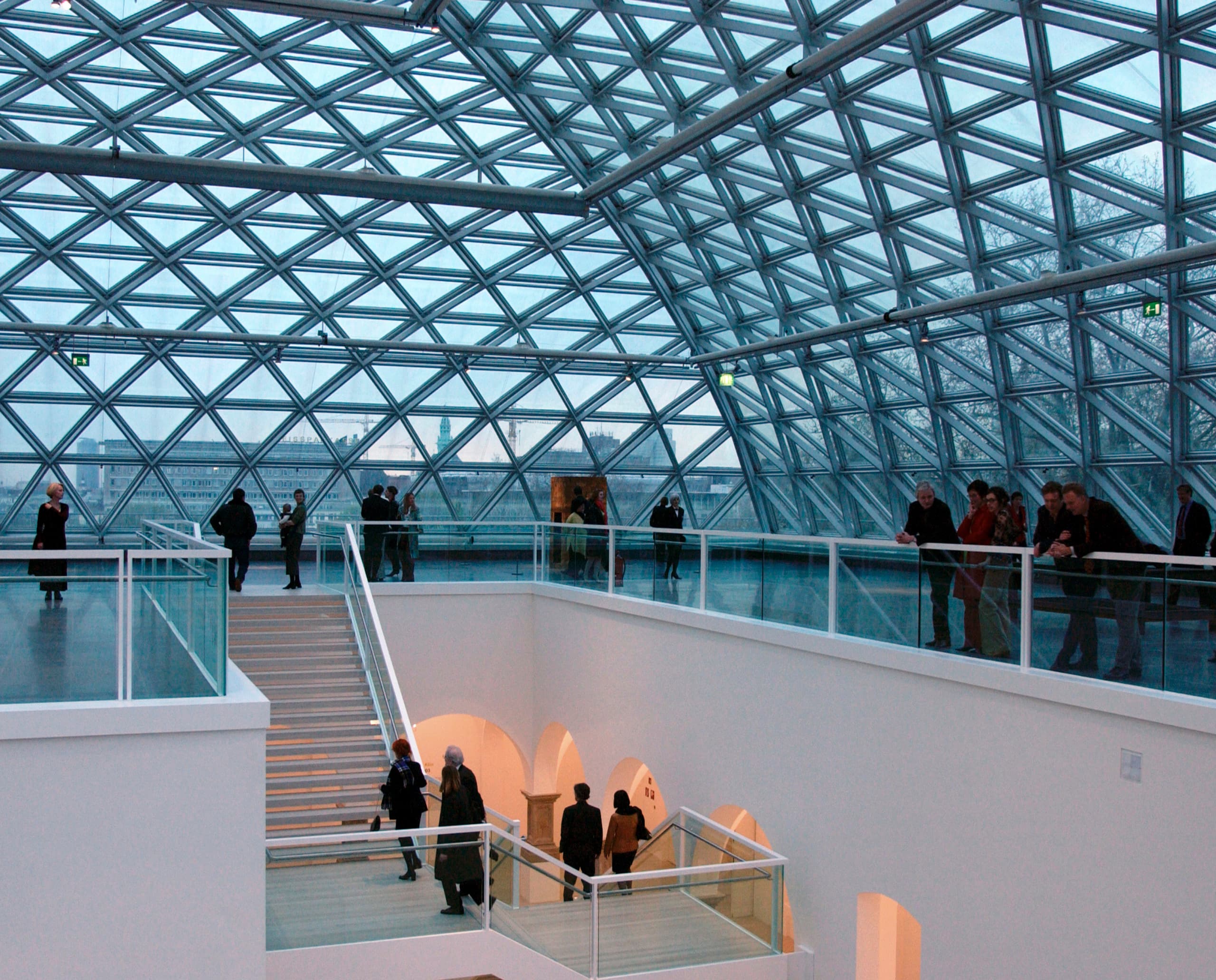 Innenansicht der K21 Kunstsammlung mit Glasdach und Besuchern, beleuchtet mit ERCO Licht.