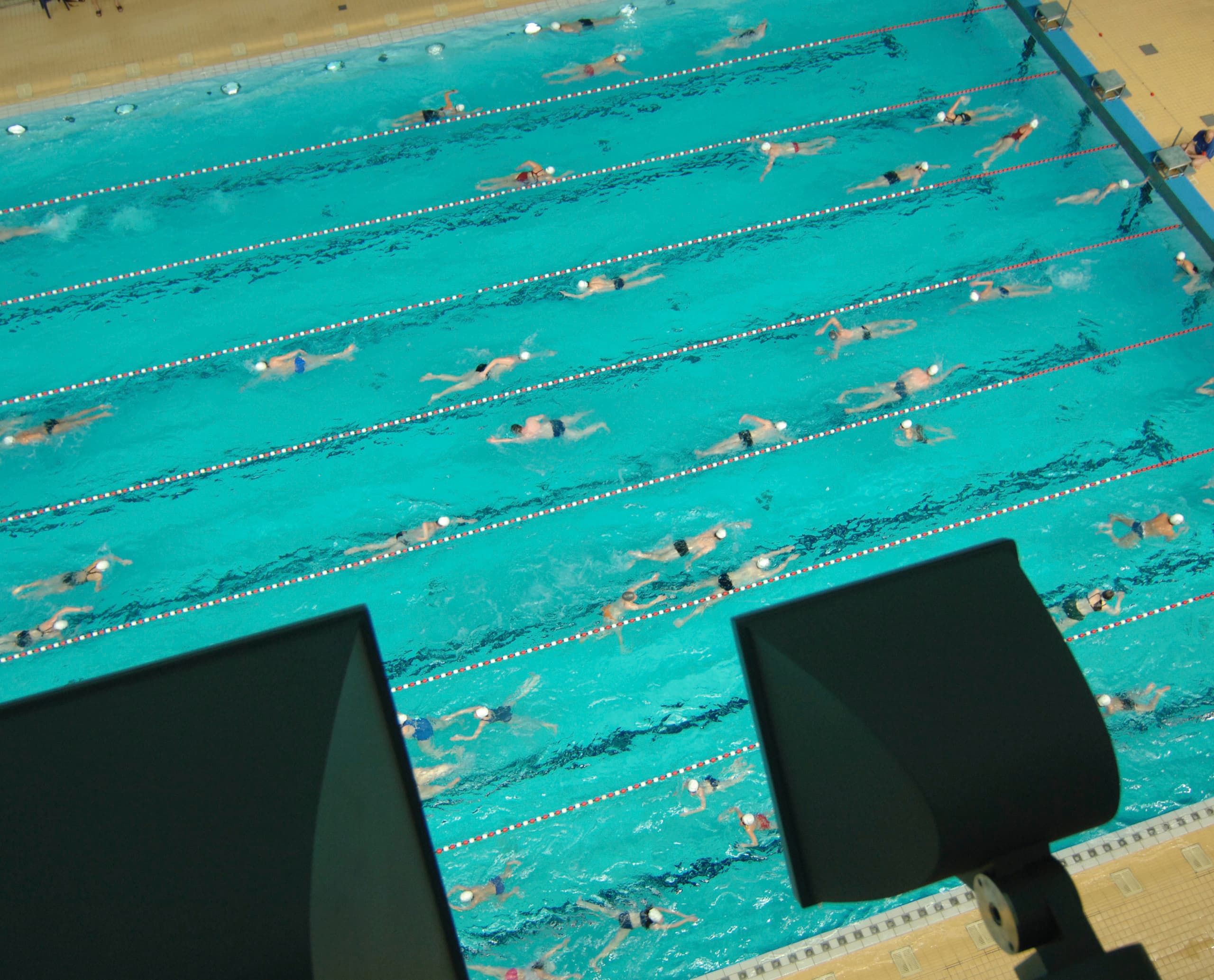 Olympia Schwimmhalle München mit ERCO Focalflood Flutern für helle Wettkampfbeleuchtung.