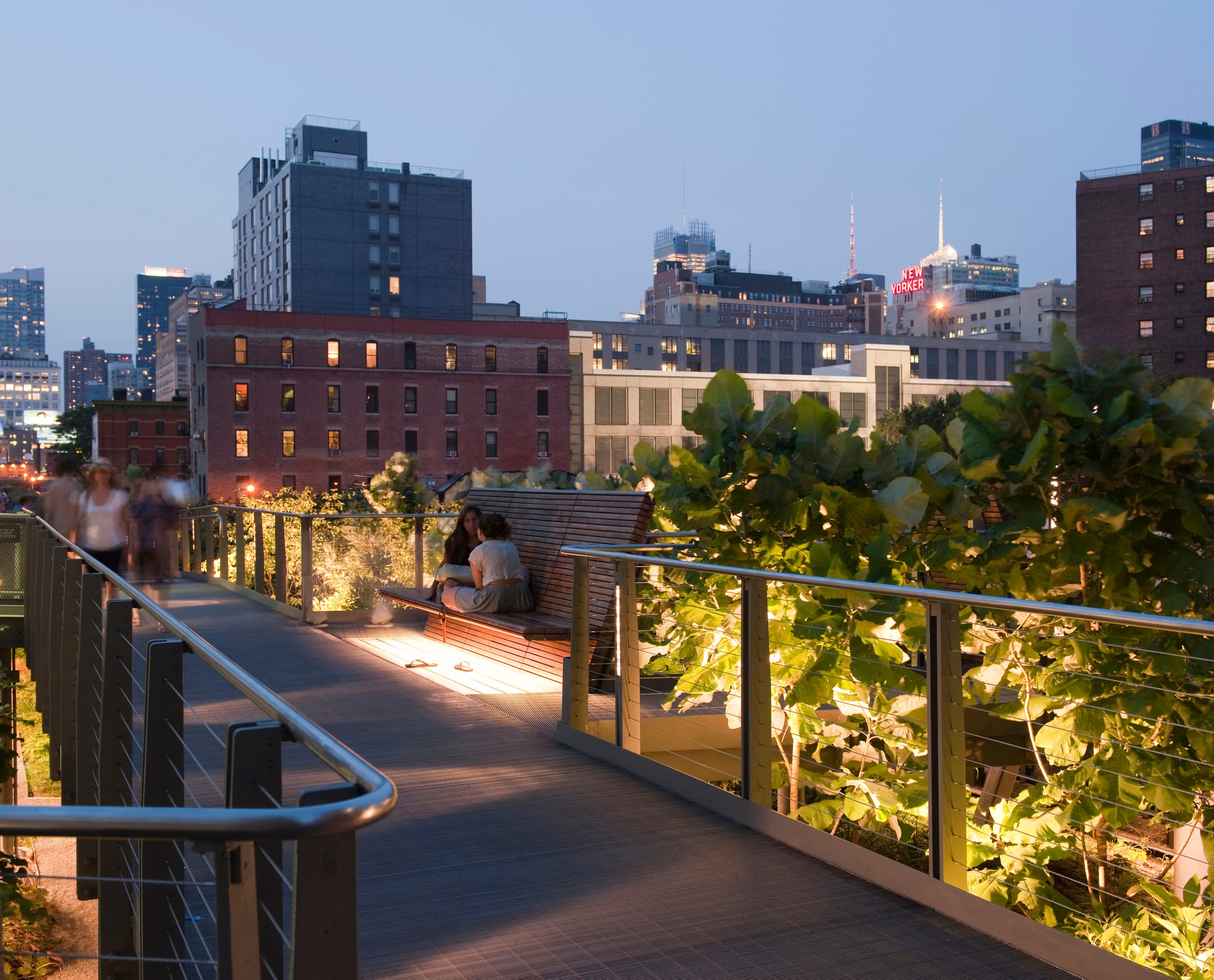 ERCO Lichtlösung im Highline Park: Beleuchteter Weg mit Sitzgelegenheiten in urbaner Umgebung.