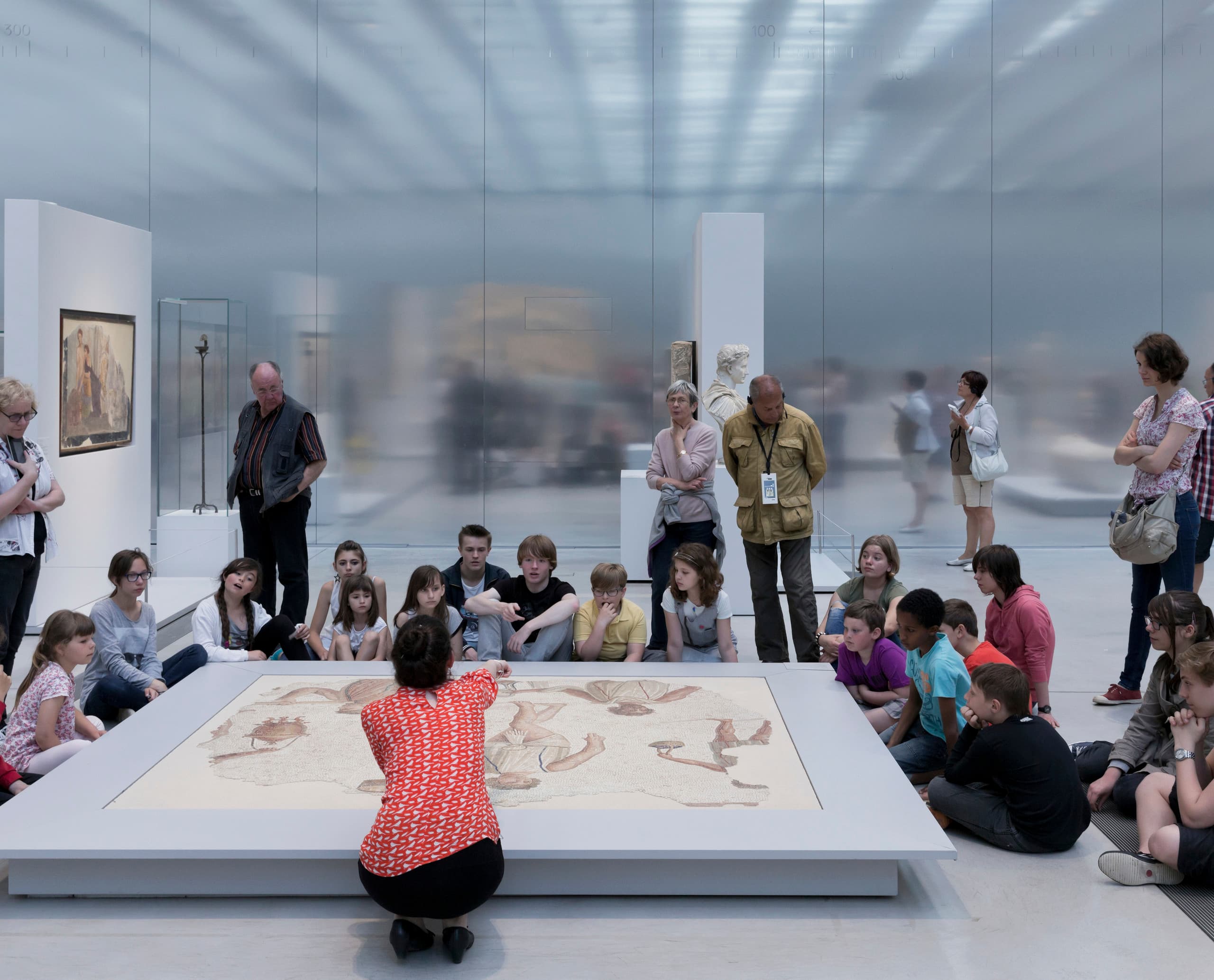 Schulklasse betrachtet ein Mosaik im Louvre Lens Museum, beleuchtet mit ERCO LED-Leuchten.