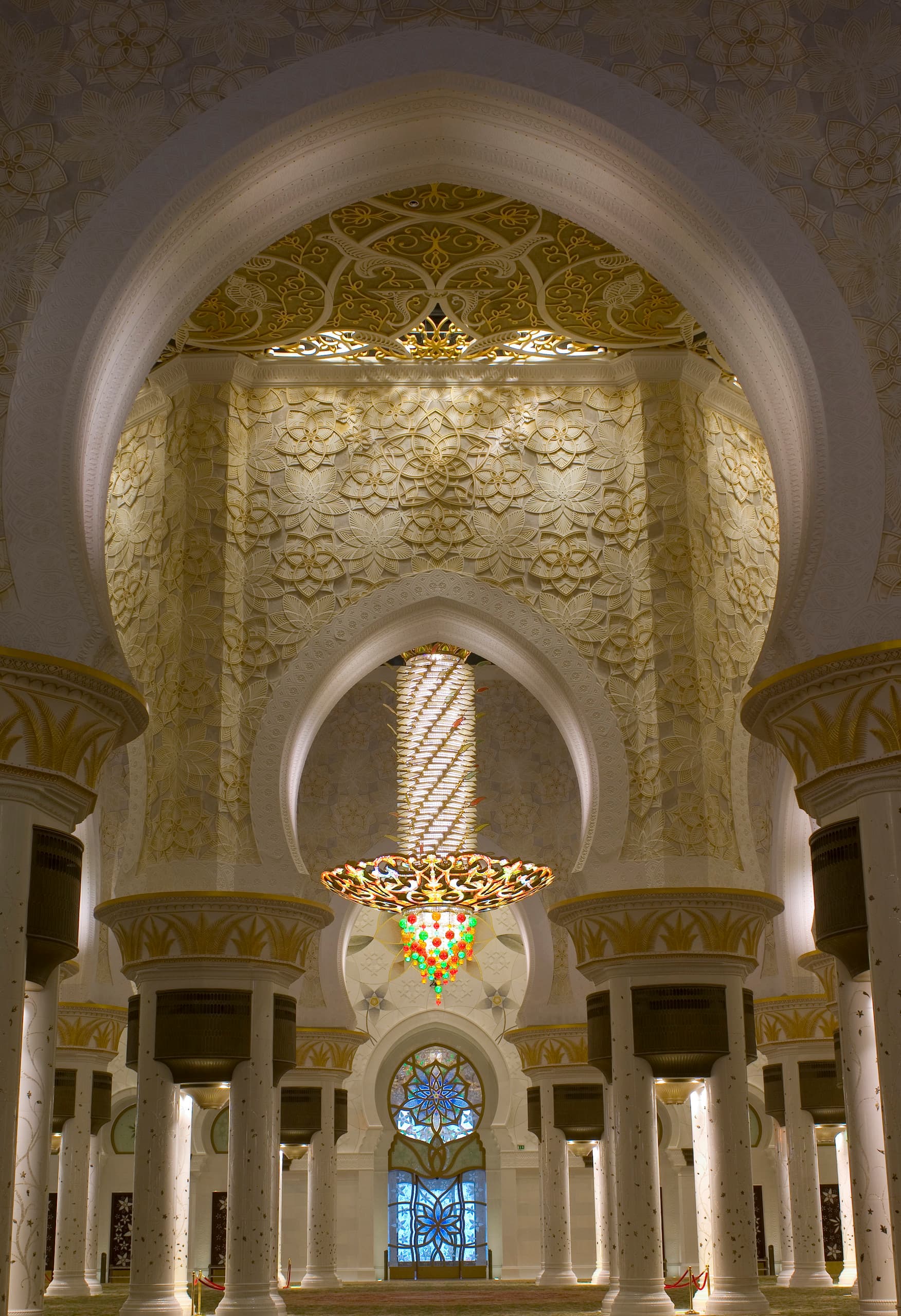 Innenansicht der Sheikh Zayed Moschee mit dekorativer Beleuchtung und kunstvollen Bögen.