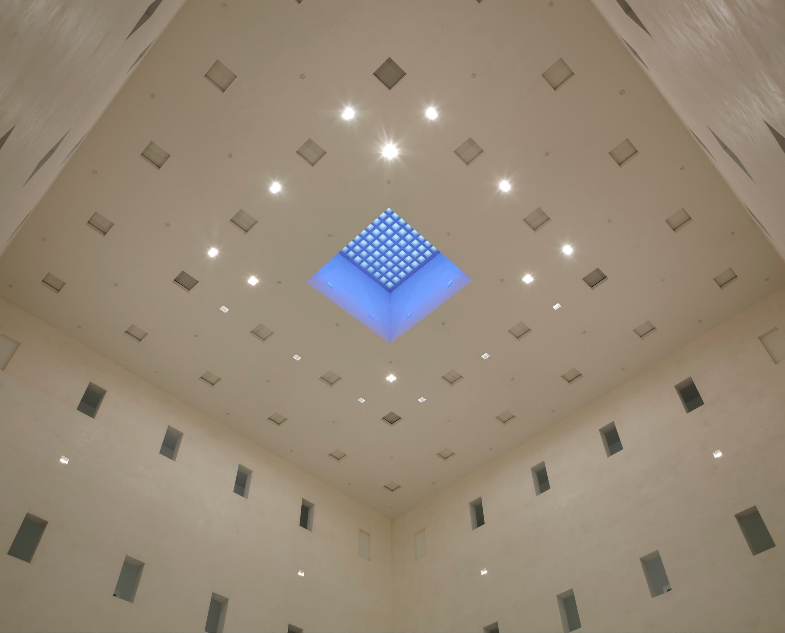 Innenansicht der Bibliothek 21 mit ERCO Quintessence Deckeneinbauleuchten und blauem Oberlicht.