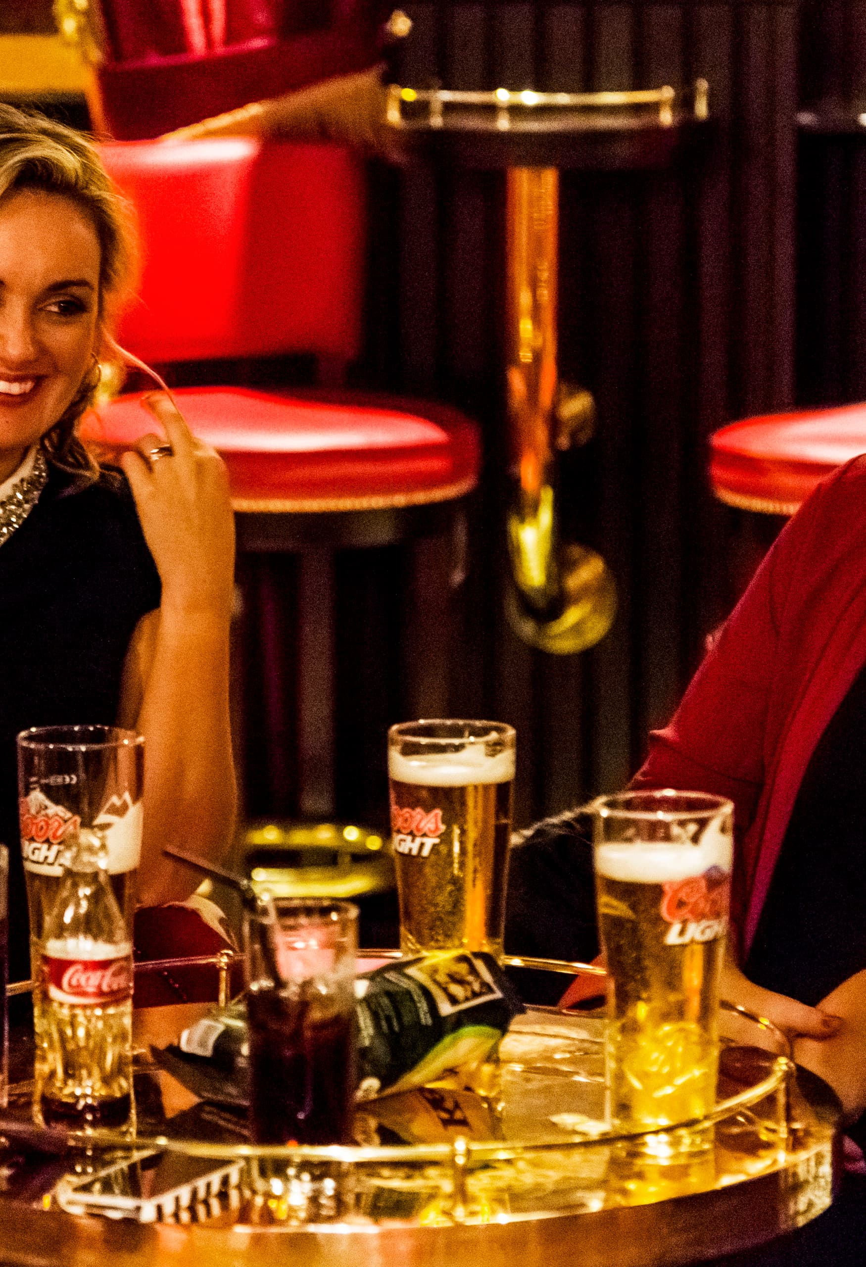 Frauen genießen Getränke in der stimmungsvollen Harp Bar, Belfast, beleuchtet mit ERCO LED-Leuchten.