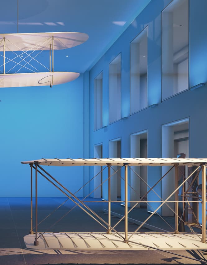 Flugzeugmodelle in einem Museum, beleuchtet mit farbigem Licht zur Akzentuierung der Ausstellungsstücke.
